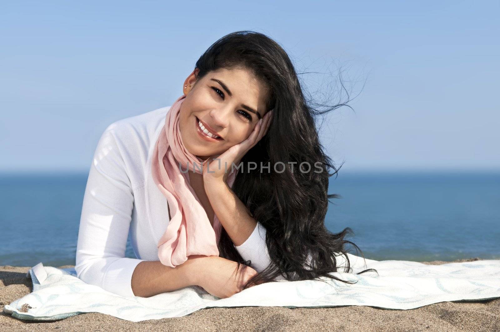 Portrait of beautiful smiling native american girl laying at beach