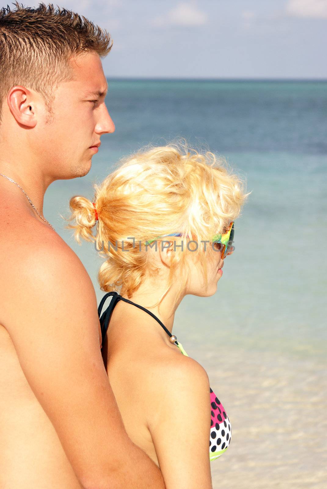 A young couple looking out over the ocean.