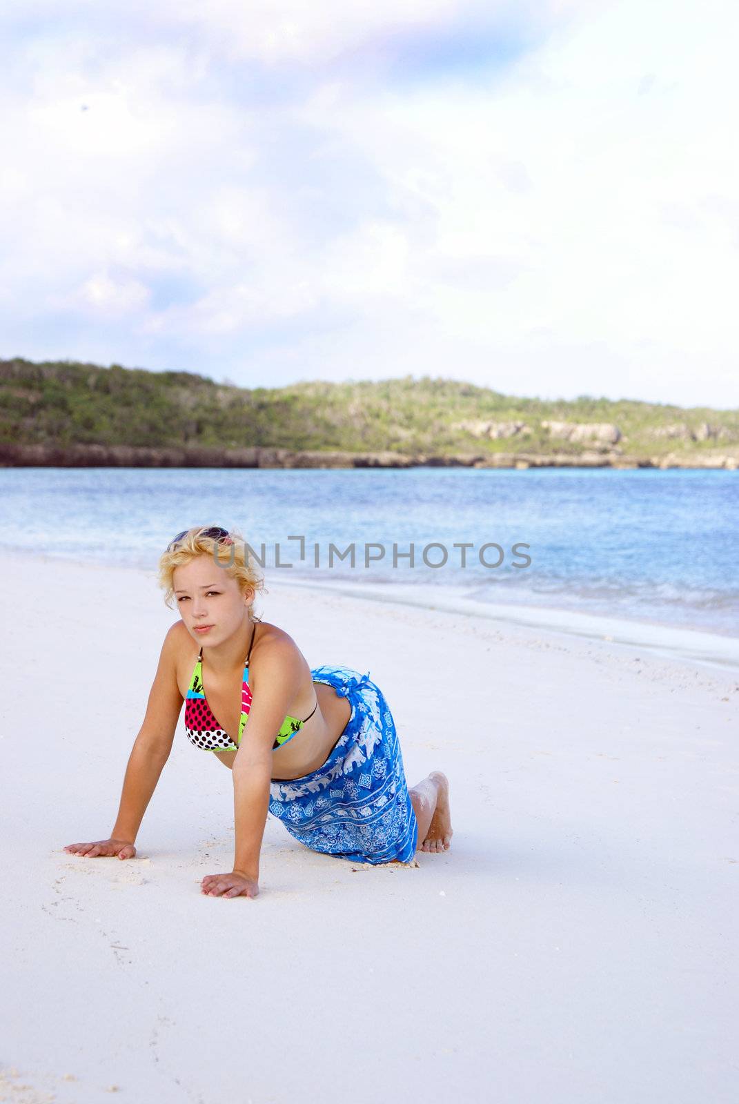 A young girl is posing on the beach.