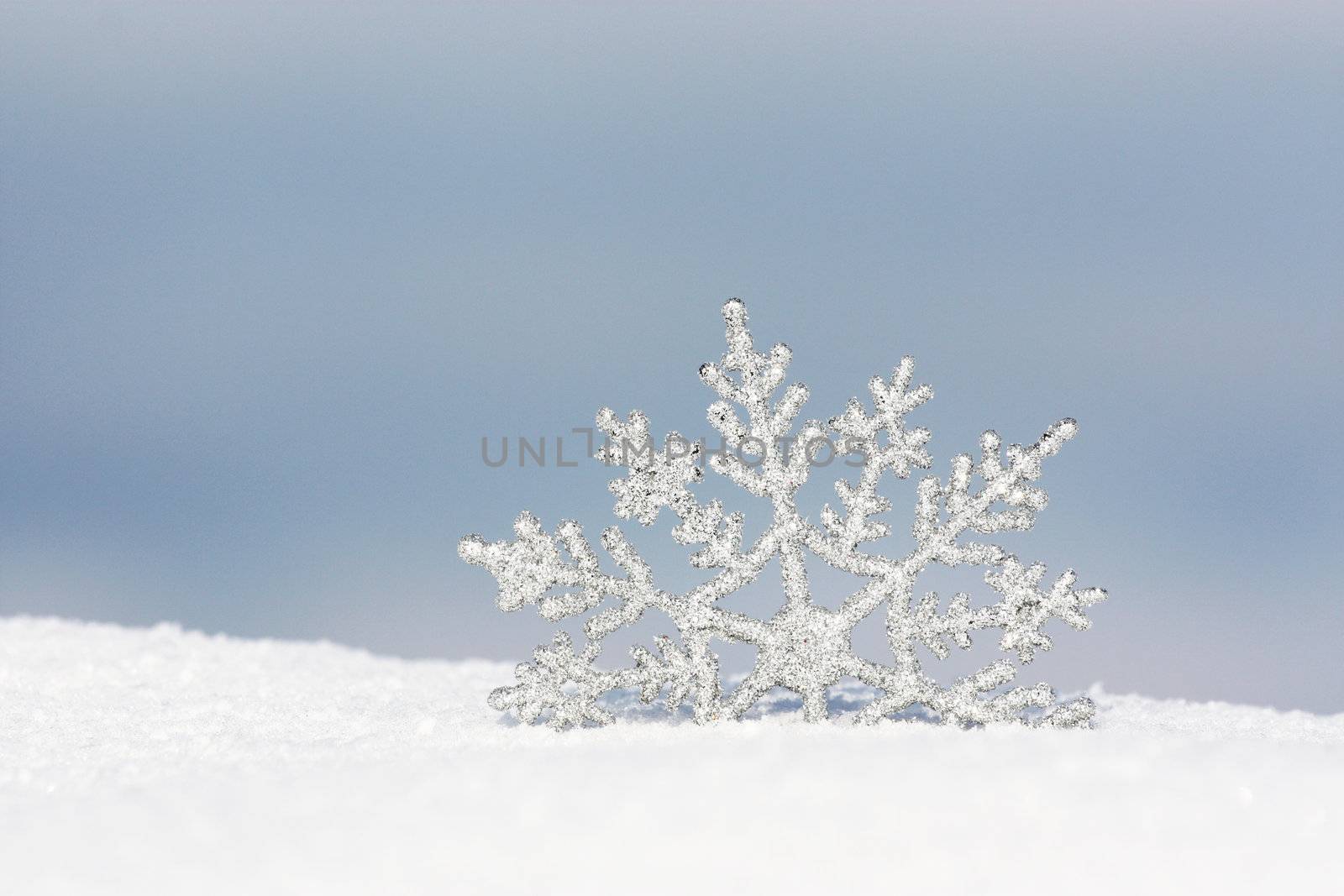 snowflake in snow by photochecker