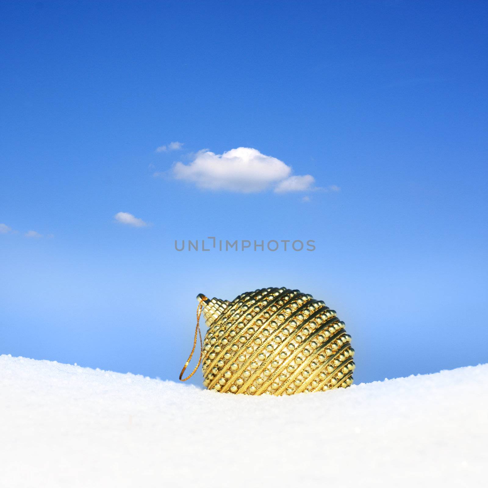 golden christmas bauble in snow