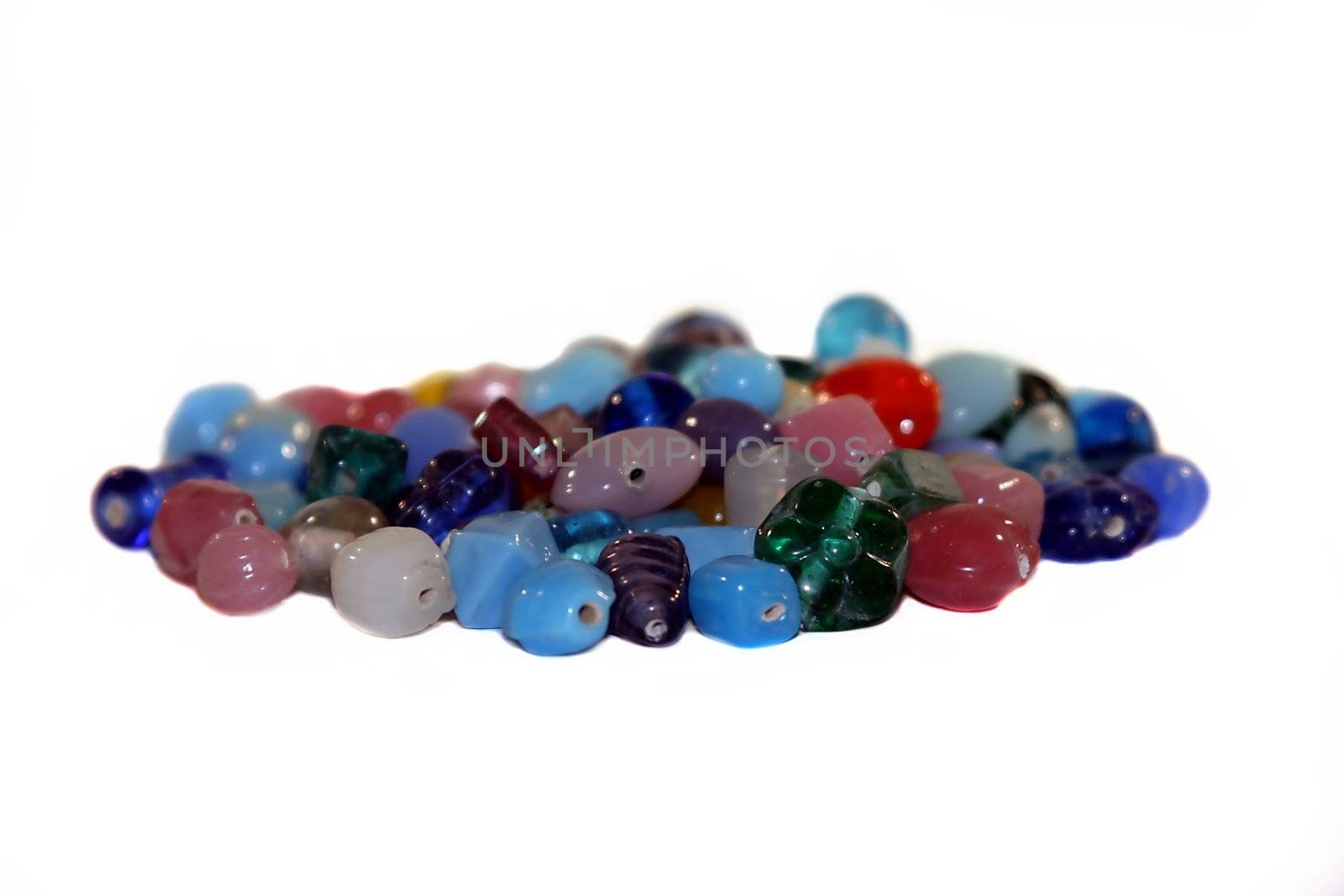 Colorful gemstones in a pile on white background.