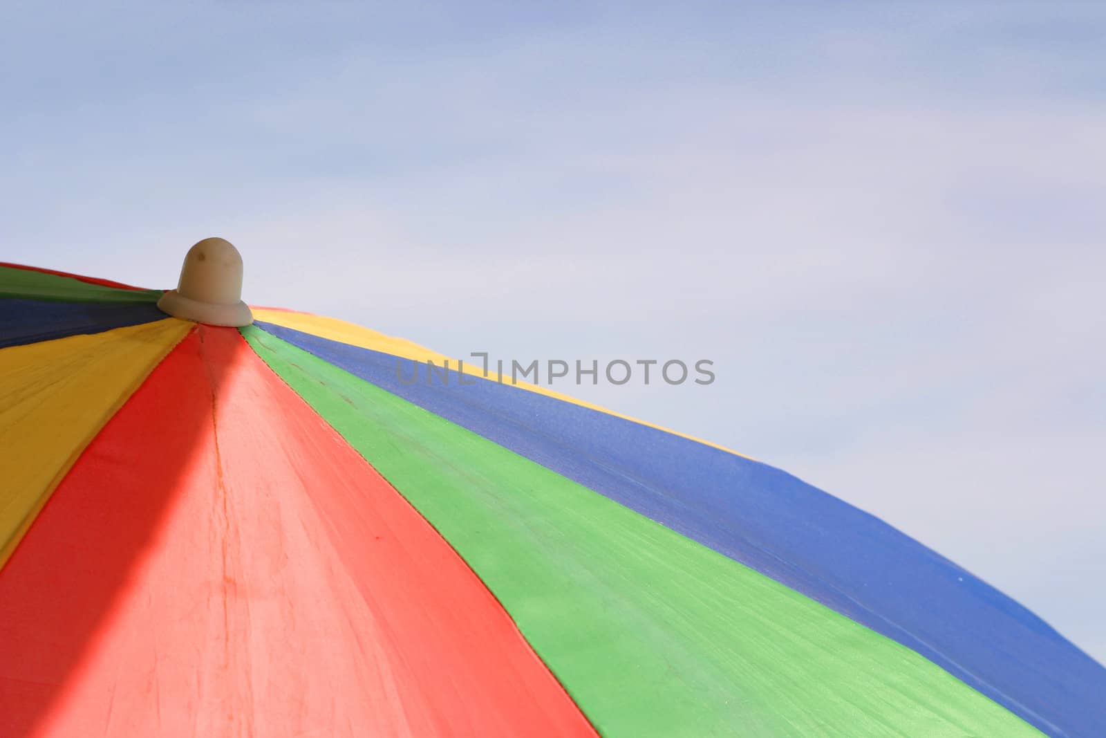 multi coloured parasol against a blue sky