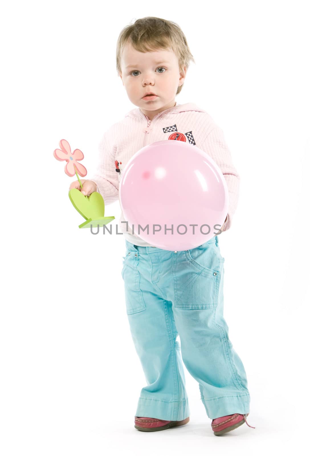 Child with pink jacket, pink balloon, wooden flower. Isolated on white