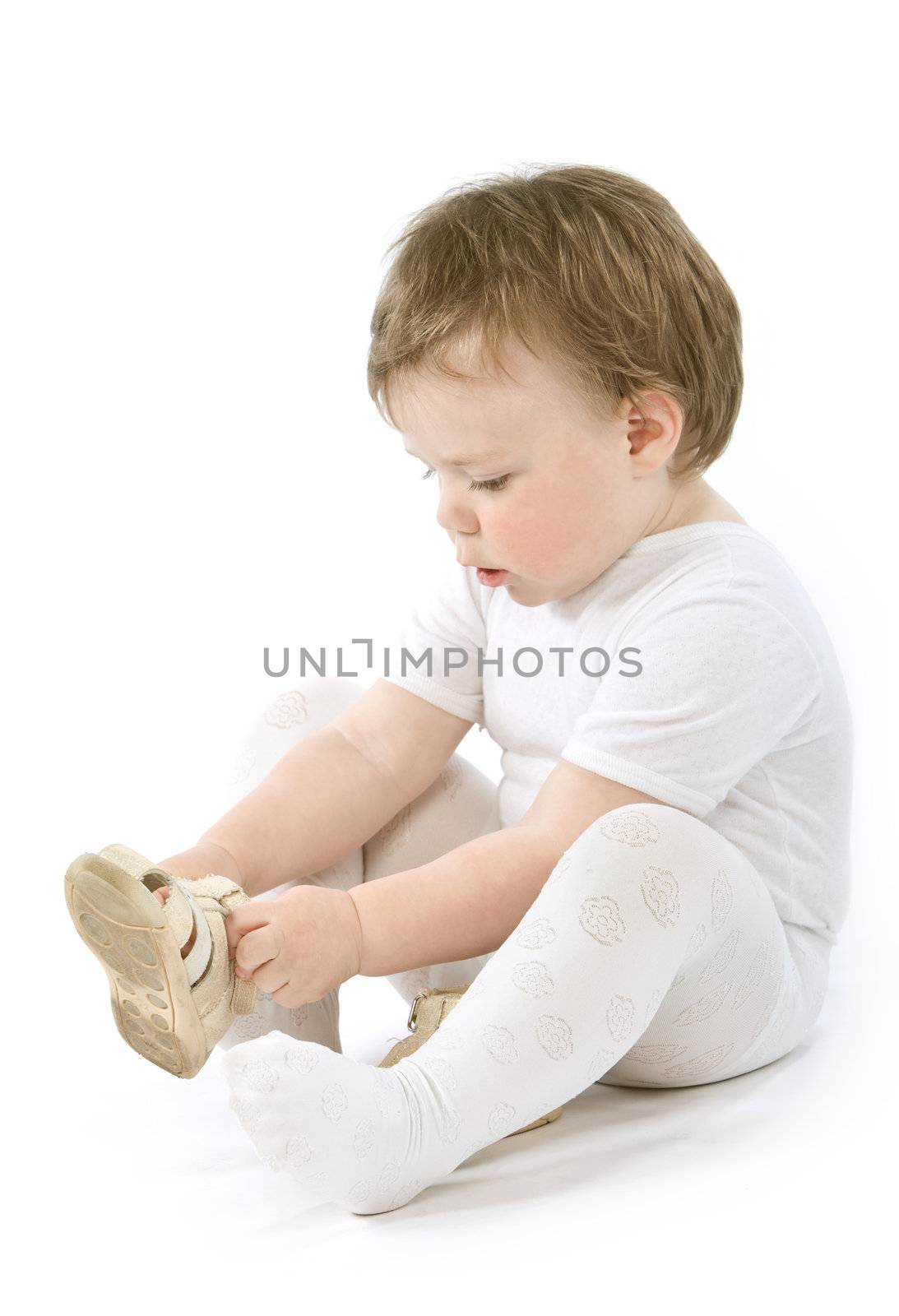 Child with shoes sitting. Isolated on white