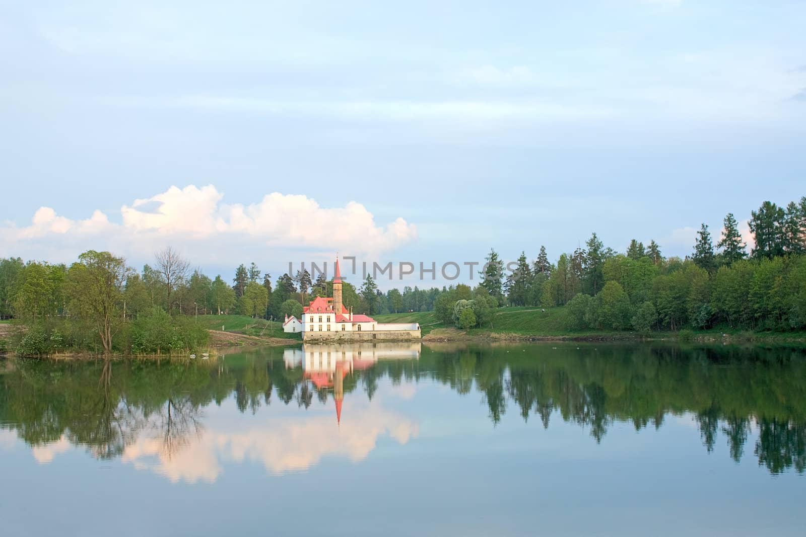 On the shore of the lake is visible Priory Palace and its reflection in the water, Gatchina, Russia.