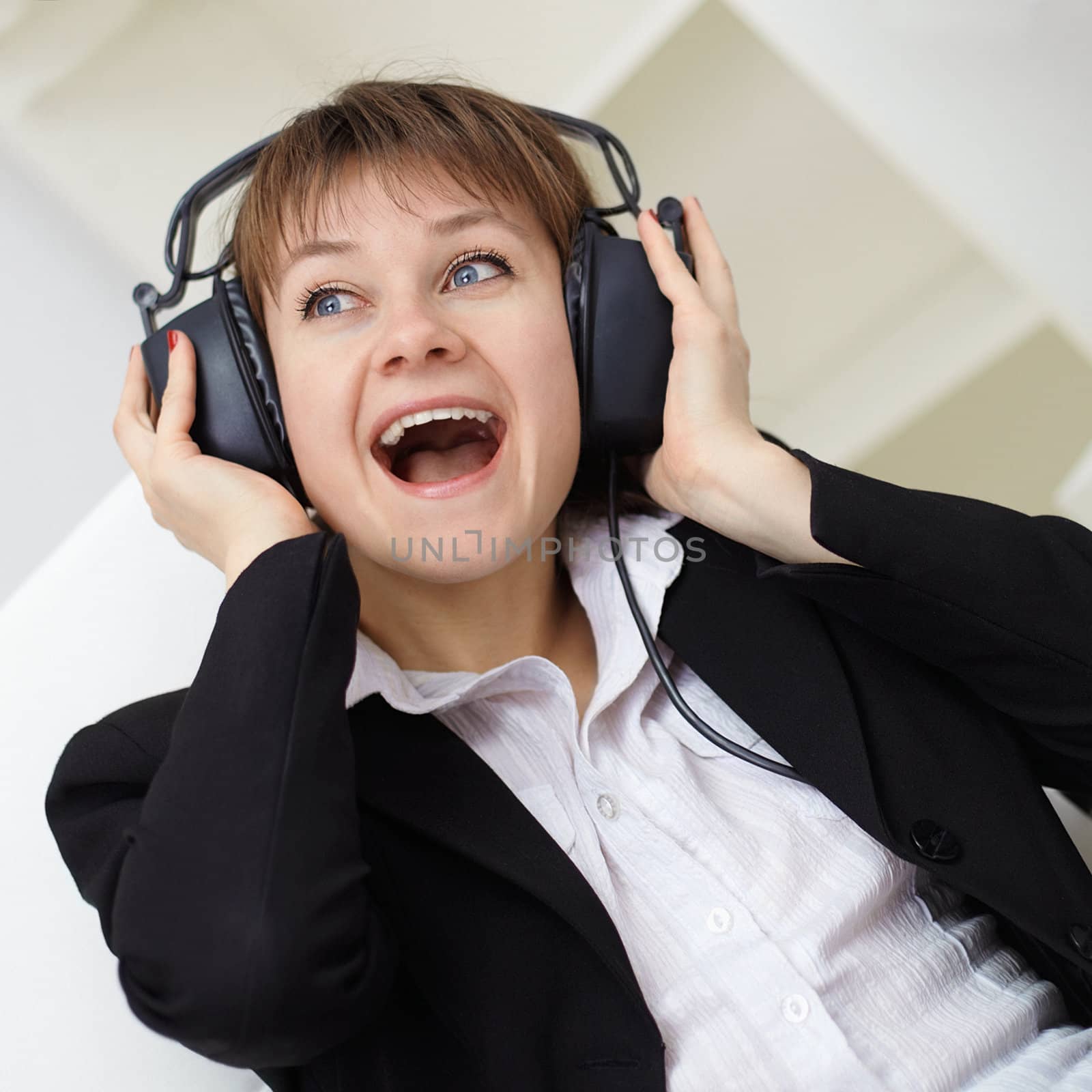 The cheerful young woman singing in ear-phones