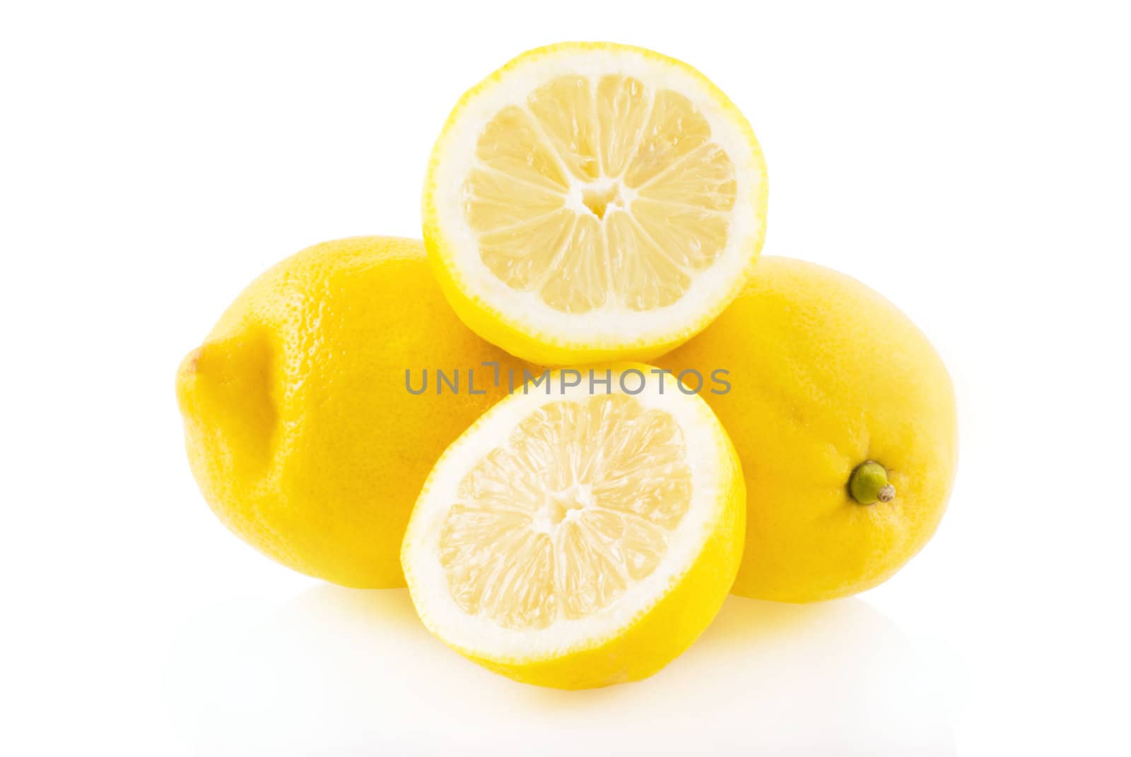 Lemon, two whole ones and one in half on a white background.