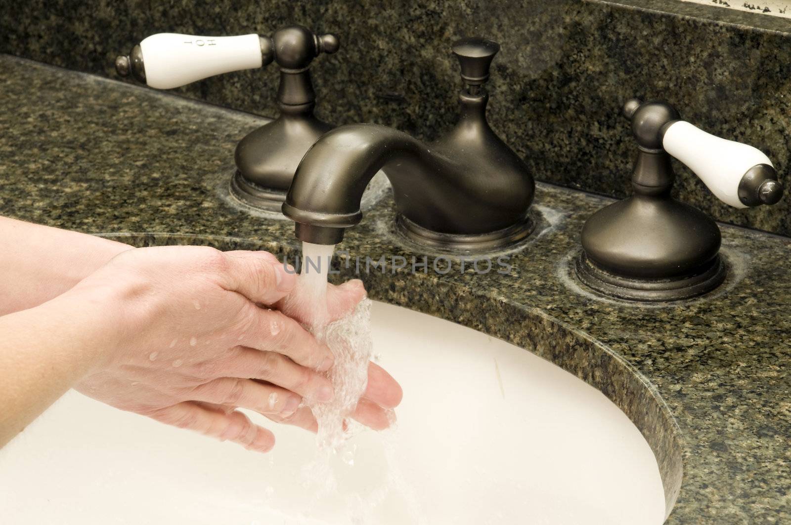 a woman washes her hands with soap and water