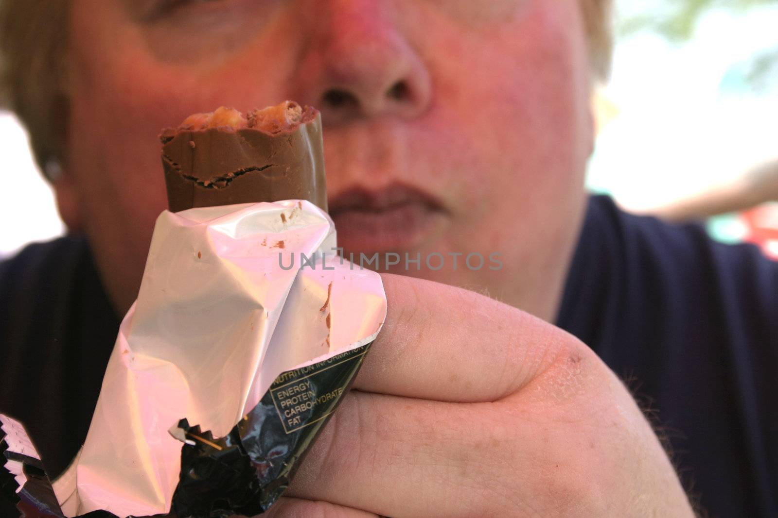 man savouring the first bite of a chocolate bar