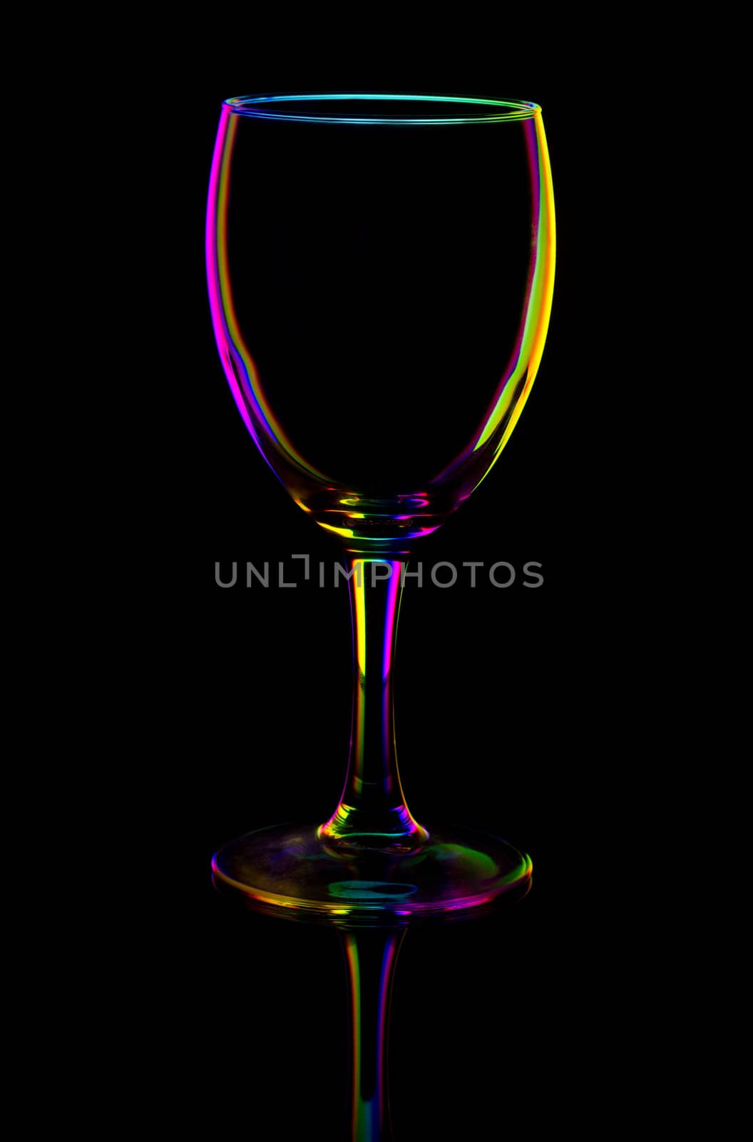 transparent colored empty wine glass, isolated on black