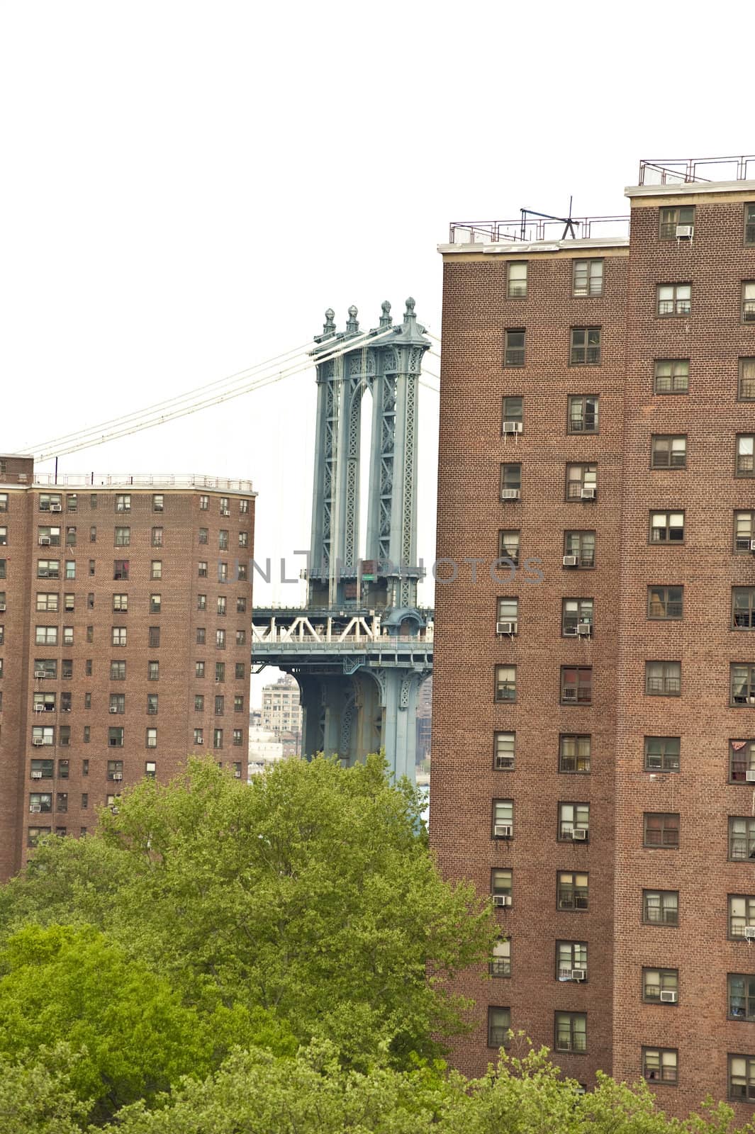 view from brooklyn bridge of apartment complex, manhattan bridge peaking through. nyc