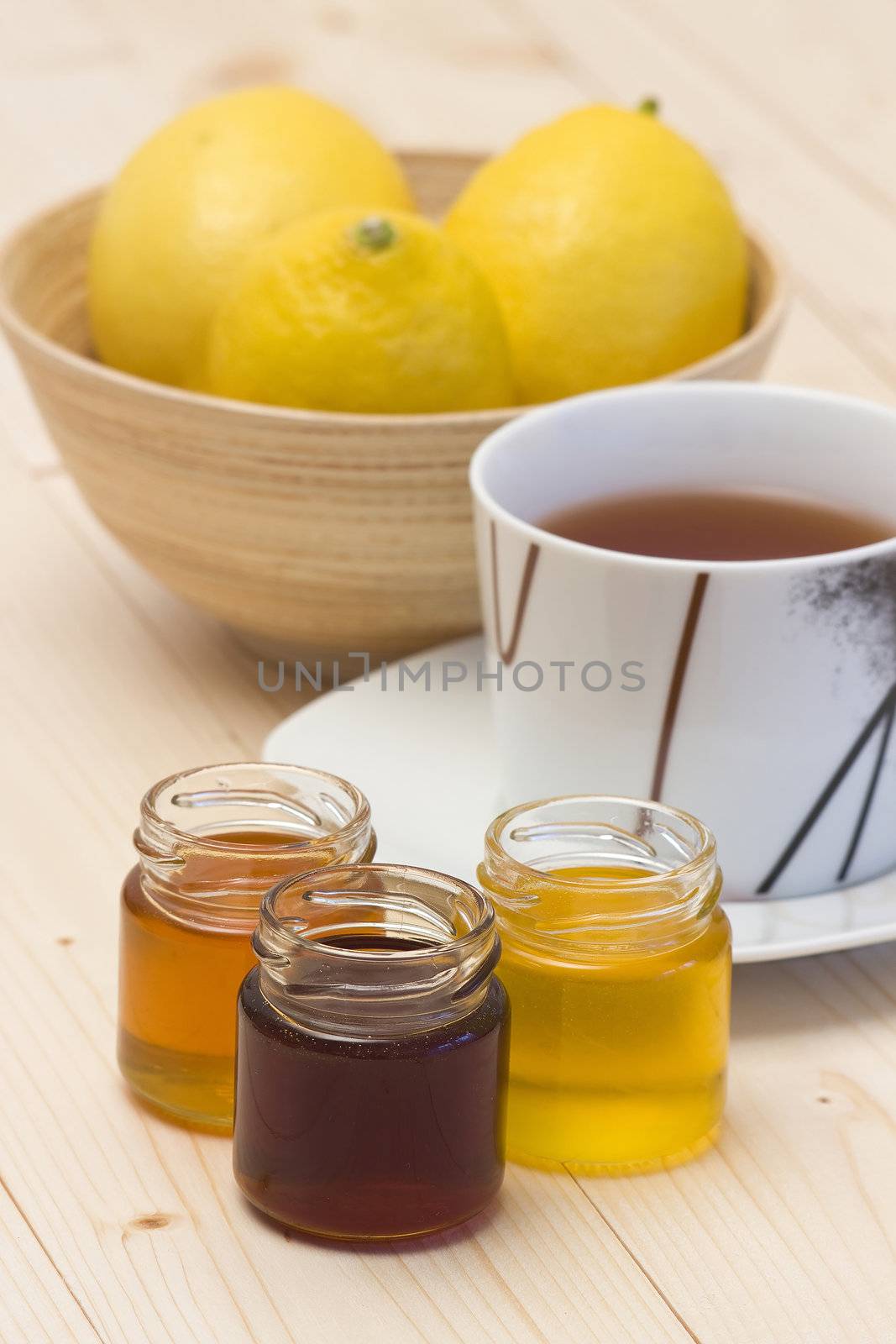 cup of lemon tea and honey by miradrozdowski