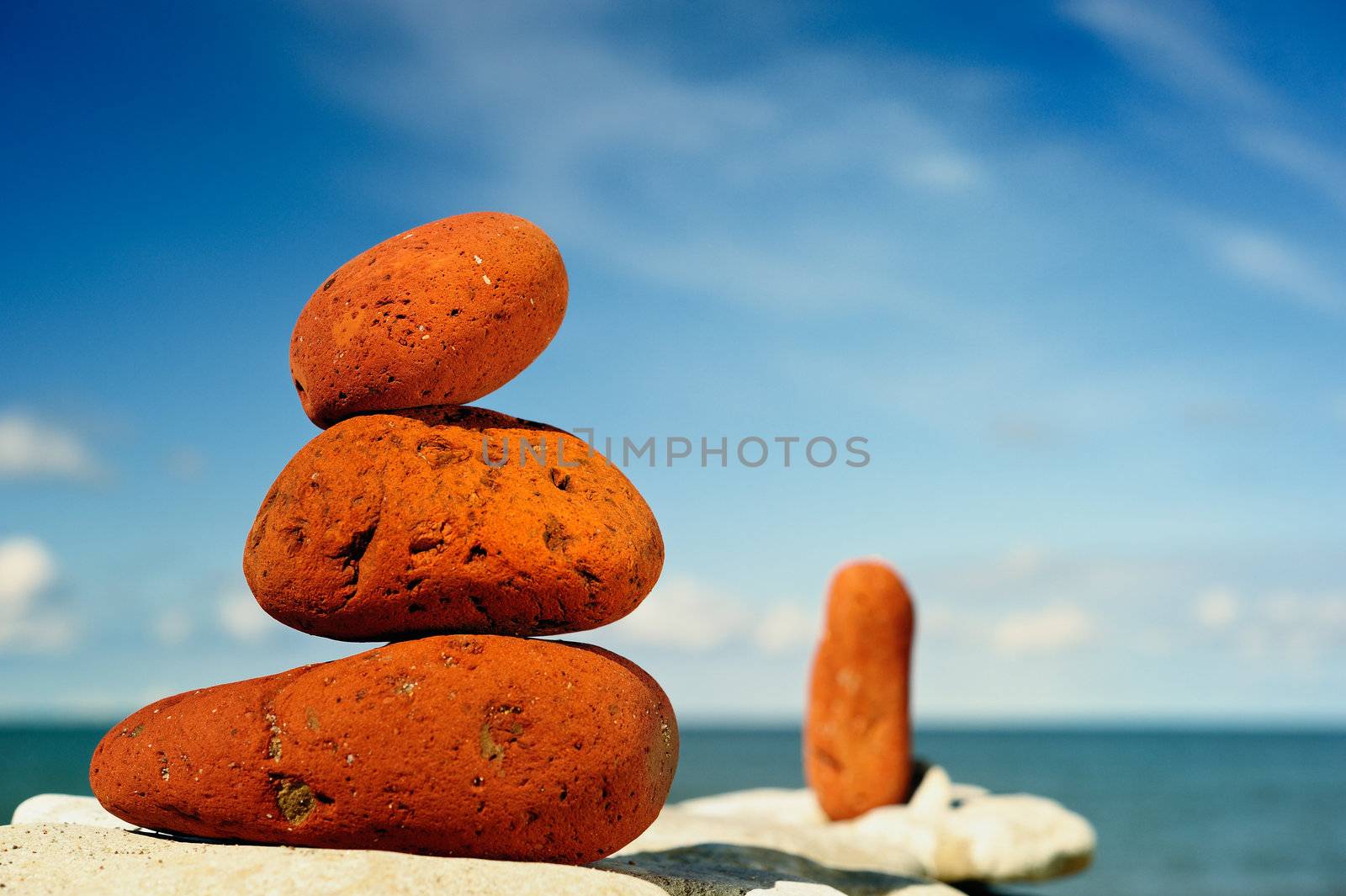 Several red pebbles one after another on a rock