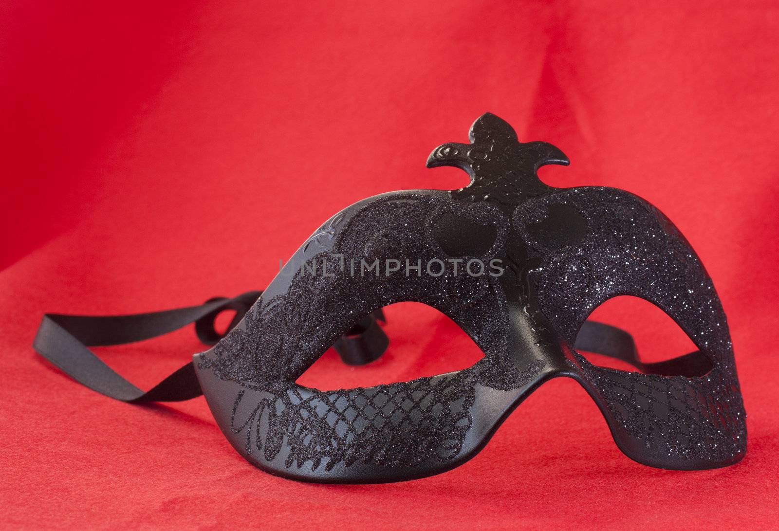 Black Carnival mask over a red background