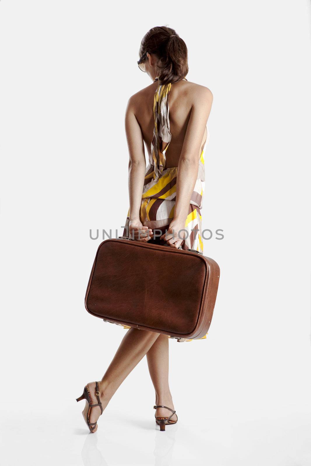 Beautiful young fashion woman posing with a old suitcase