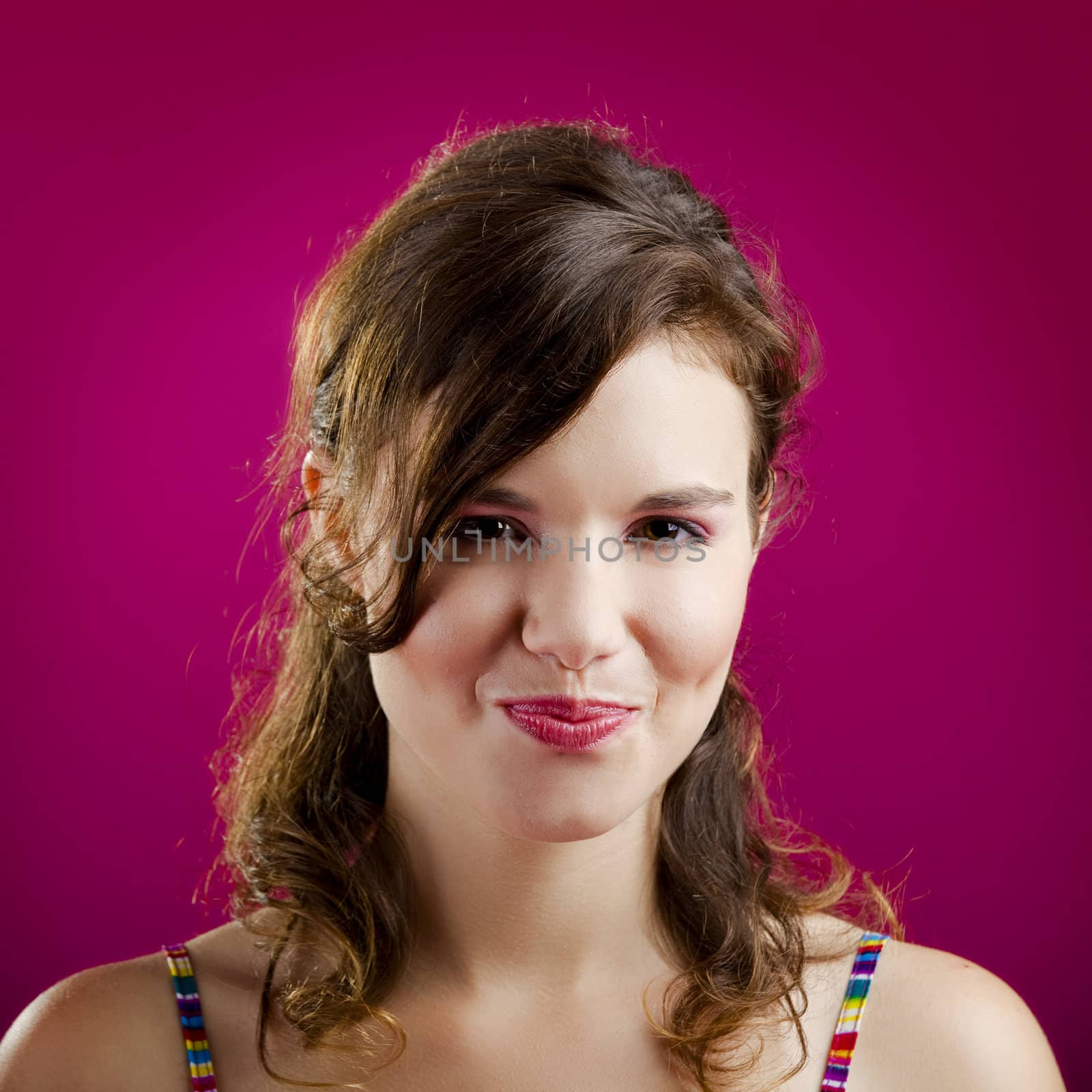 Portrait of a beautiful young woman over a pink background
