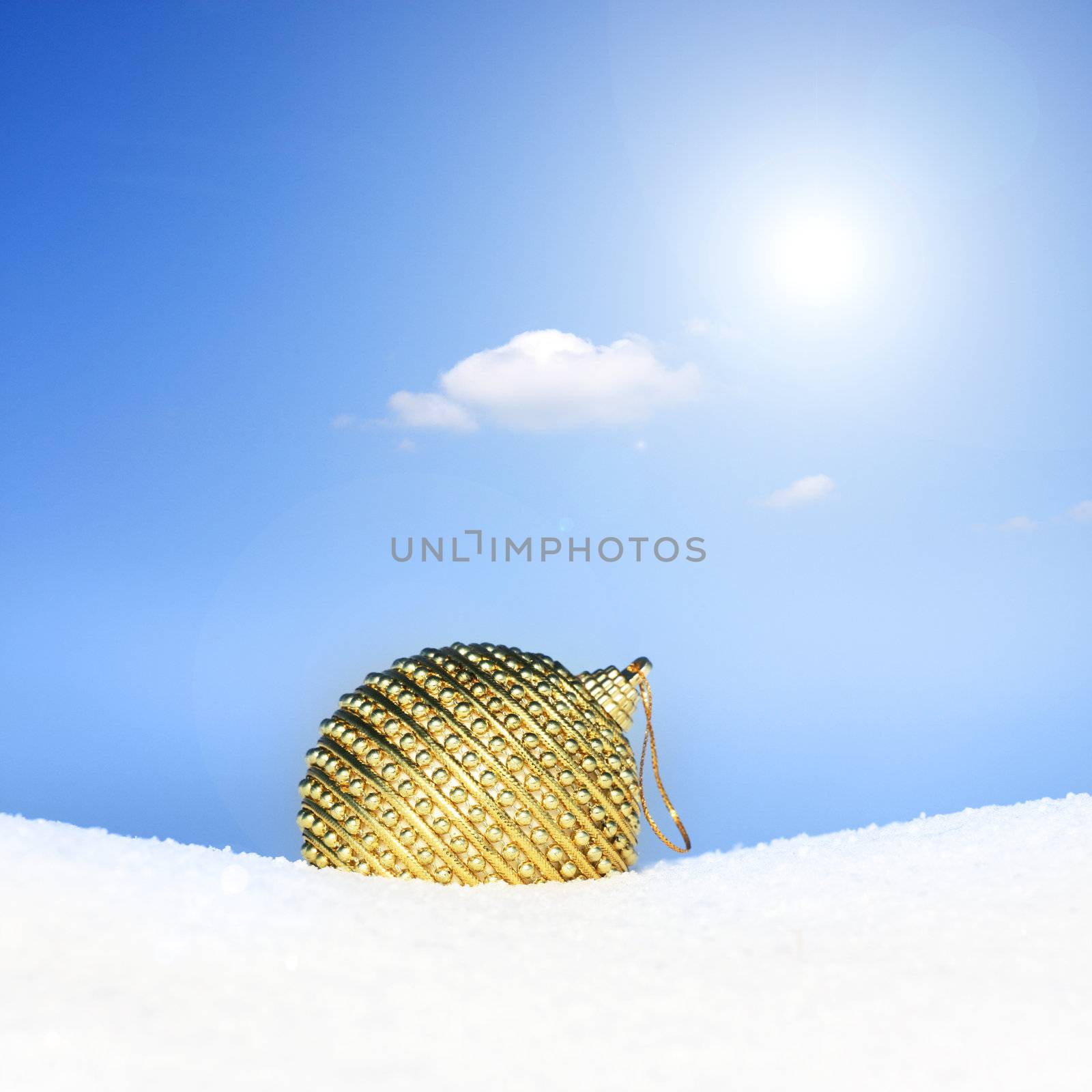 golden christmas bauble in snow