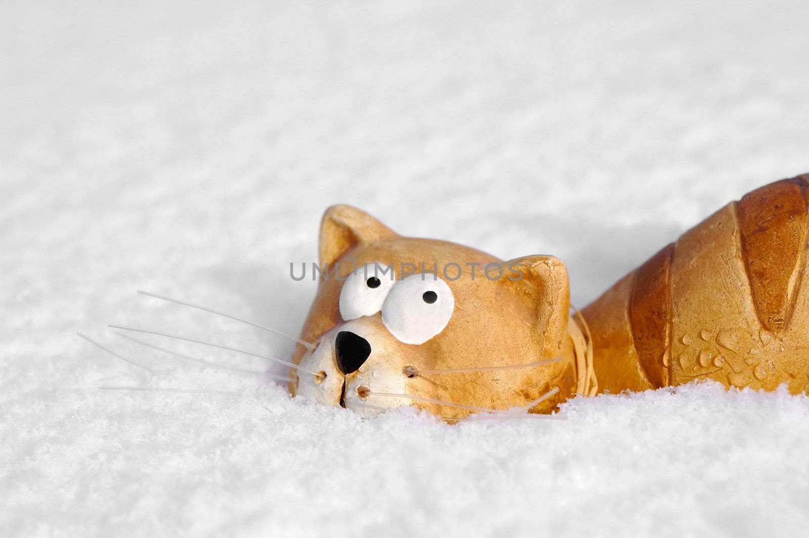 ceramic toy cat sinking into snow