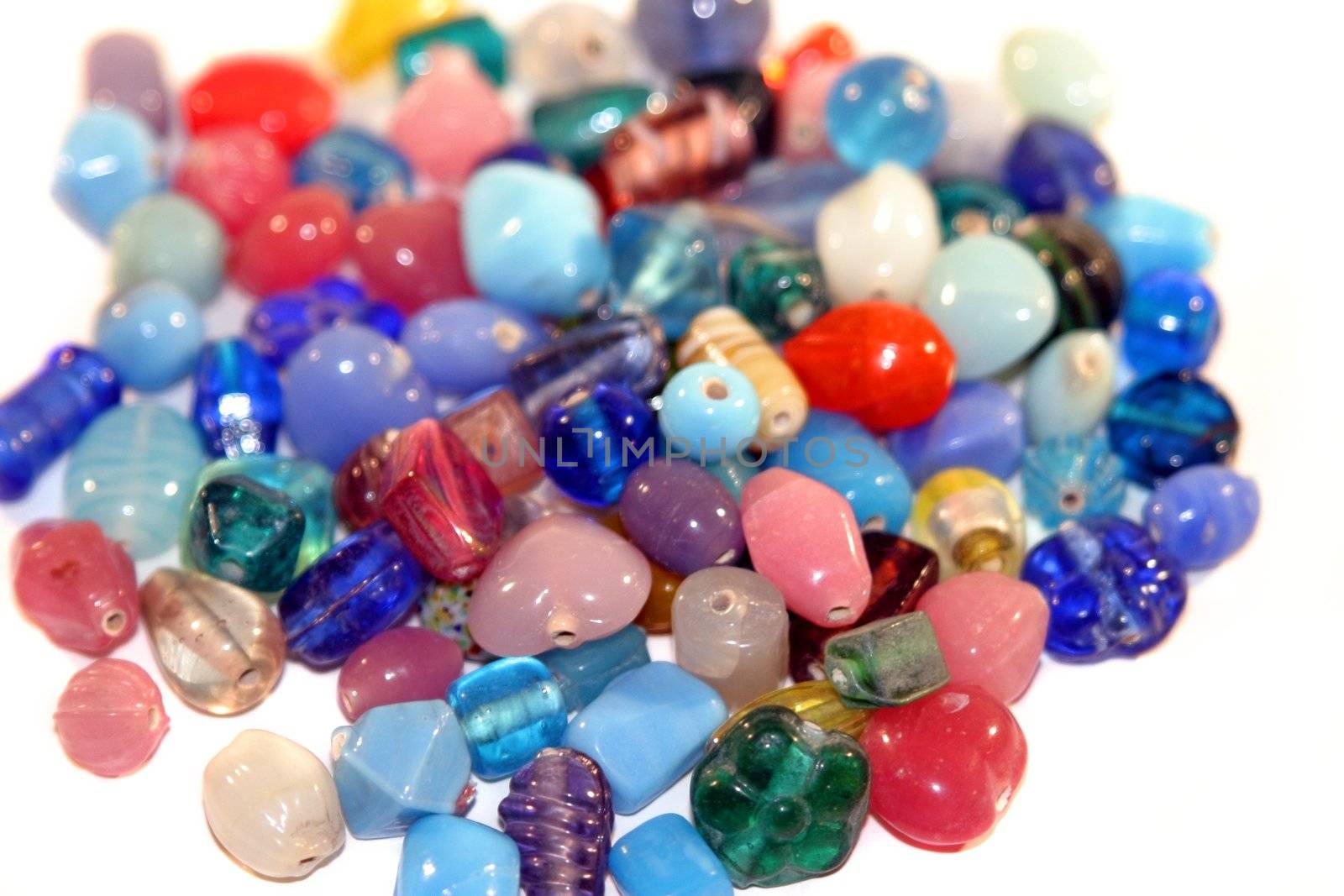Colorful gemstones in a pile on white background.