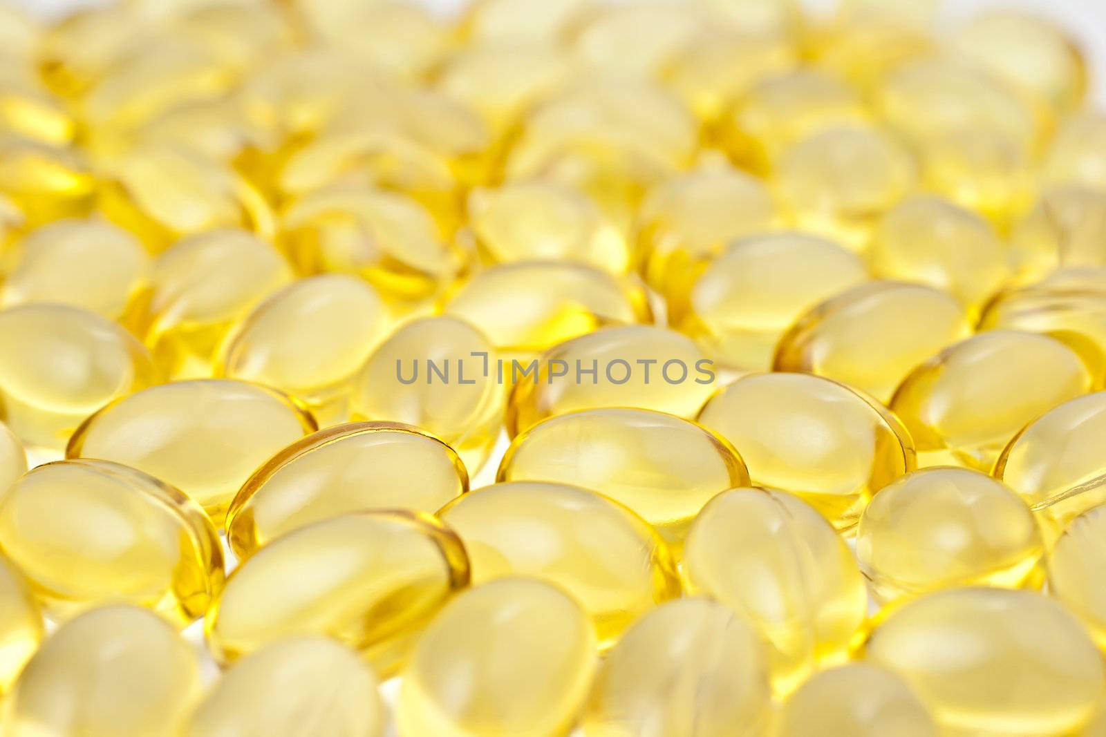 Nutritional supplement pills in warm colors and shallow depth of field. The yellow ones are vitamin E and cod liver oil. 

