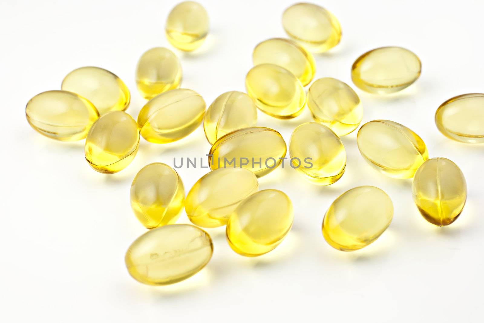 Nutritional supplement pills in warm colors and shallow depth of field. The yellow ones are vitamin E and cod liver oil.