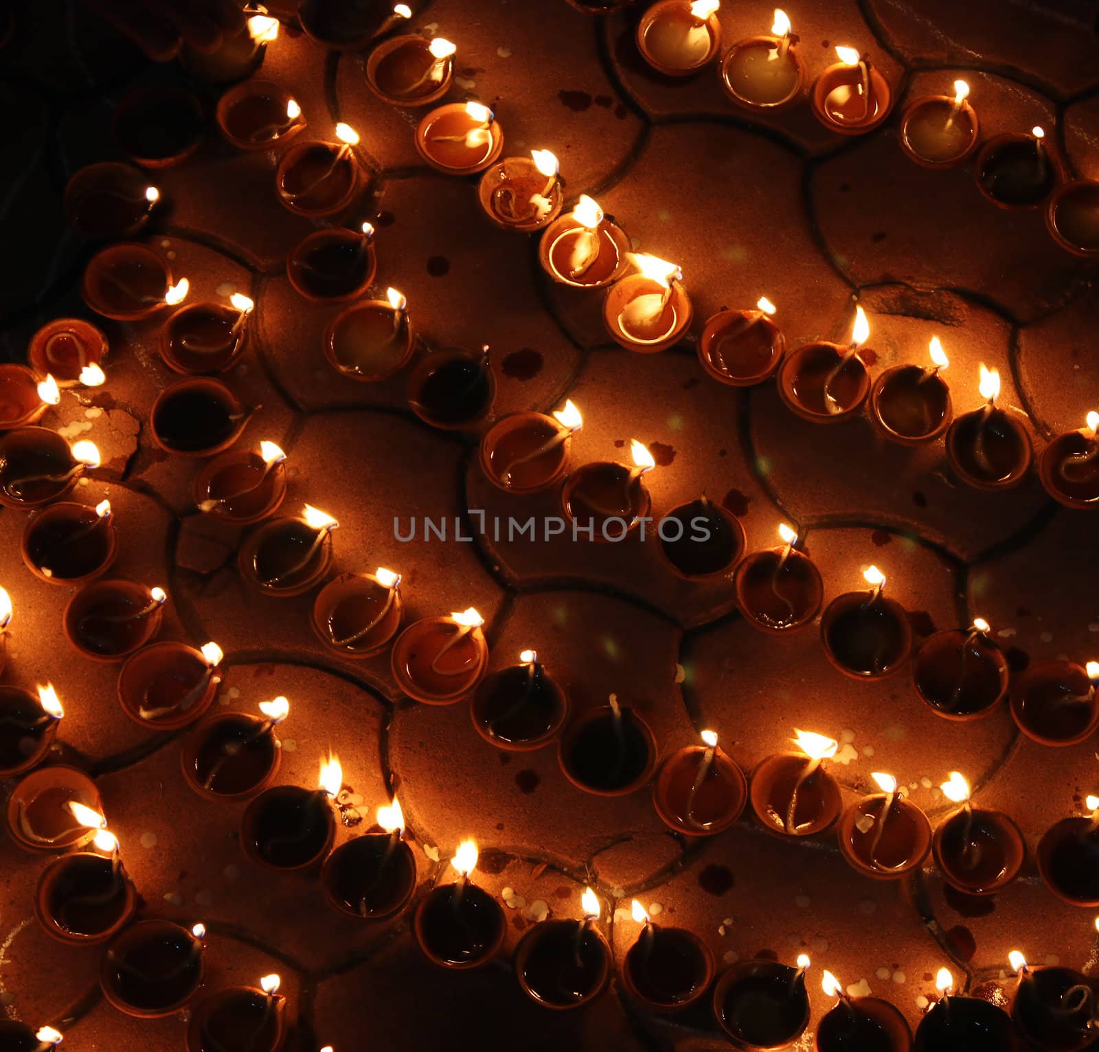 A background of traditional lit earthen lamps during Diwali festival in India.