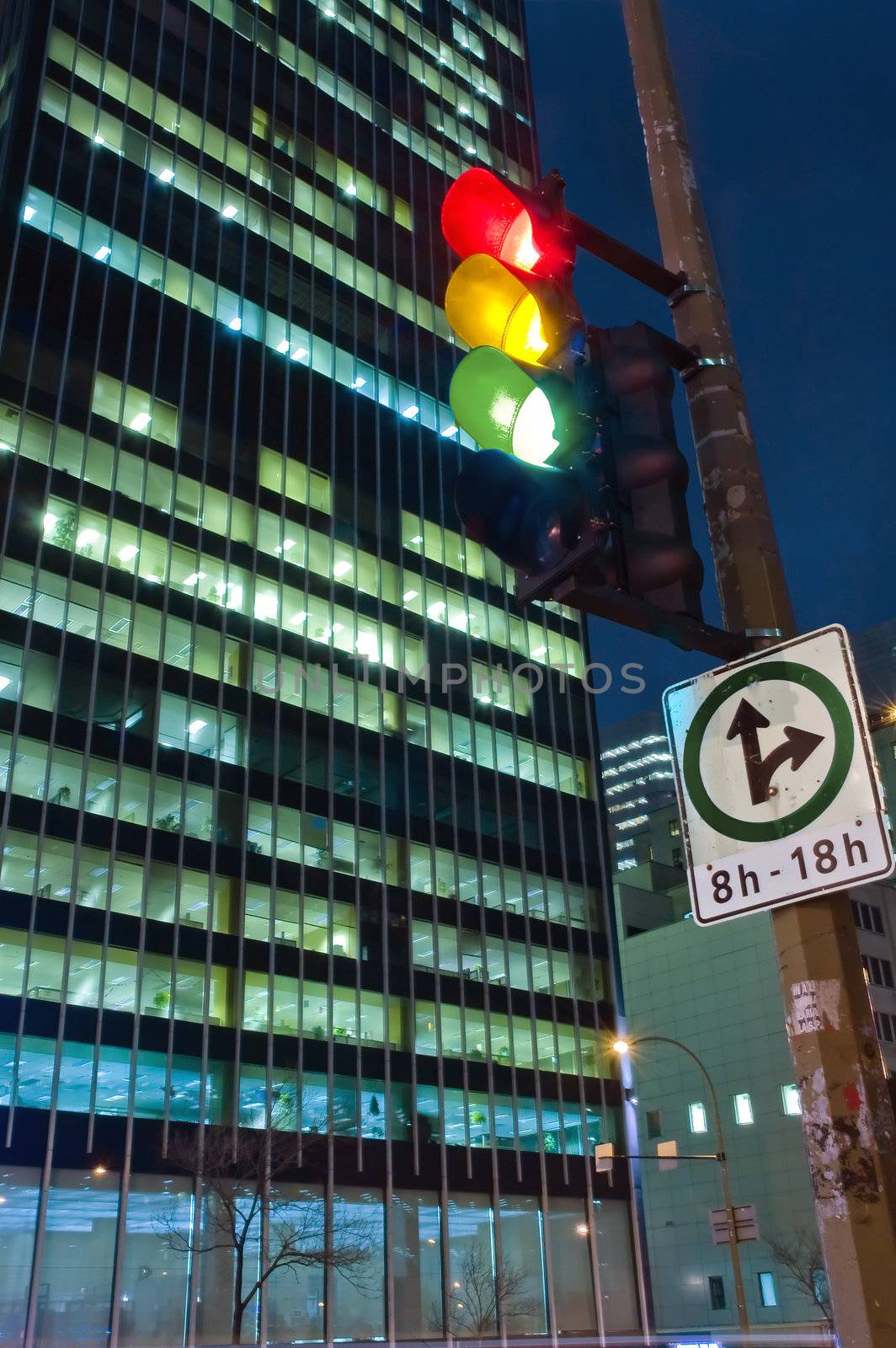 night cityscape scene with a skyscrapper and traffic light