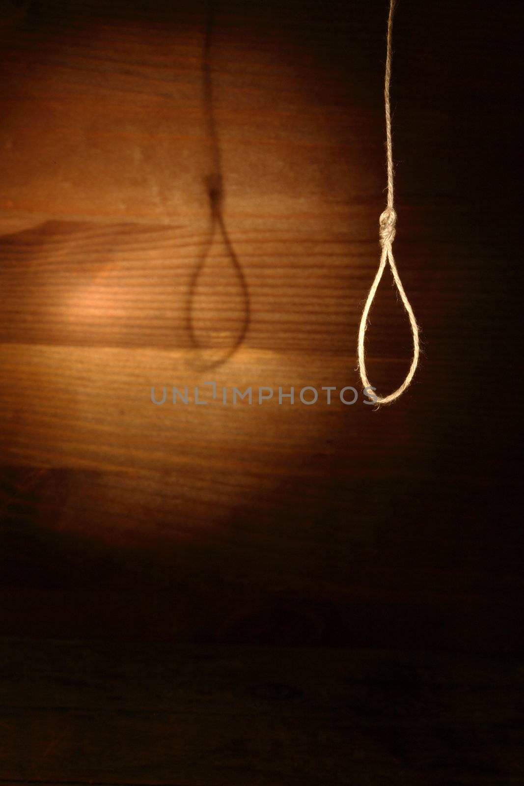 Rope loop hanging on gloomy wooden background