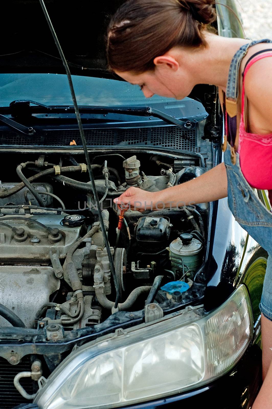 Young woman repairing her car