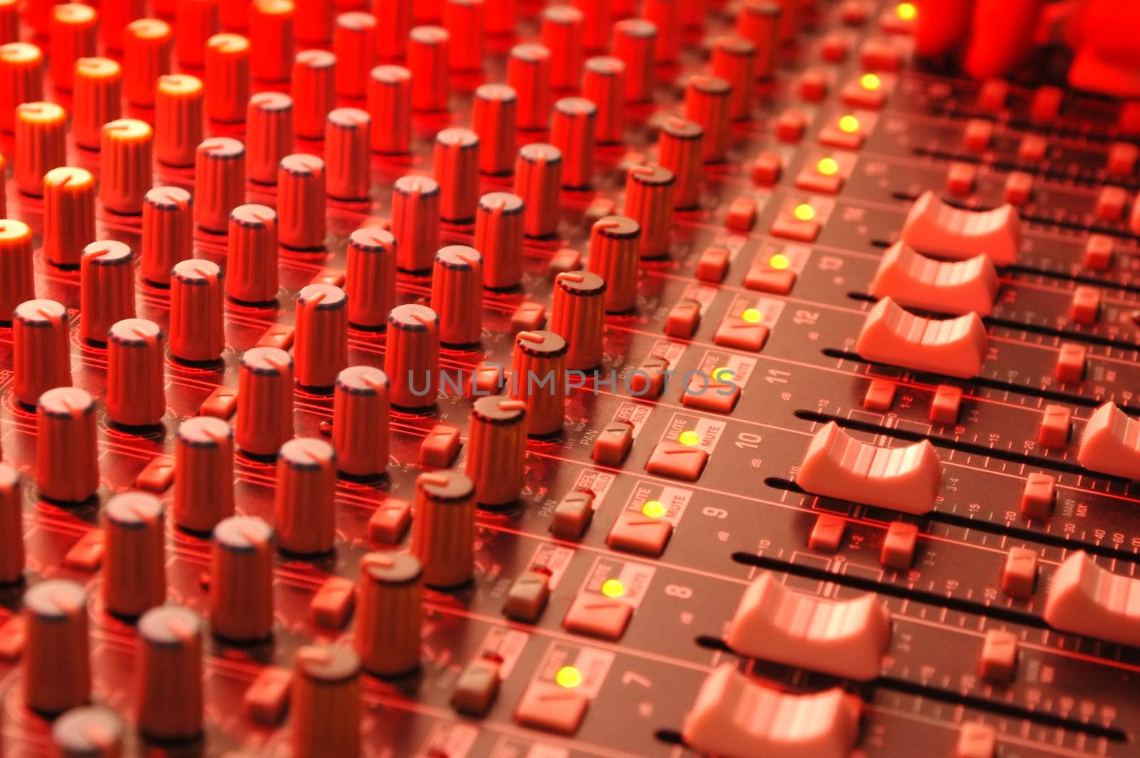 music soundboard under red stage lighting