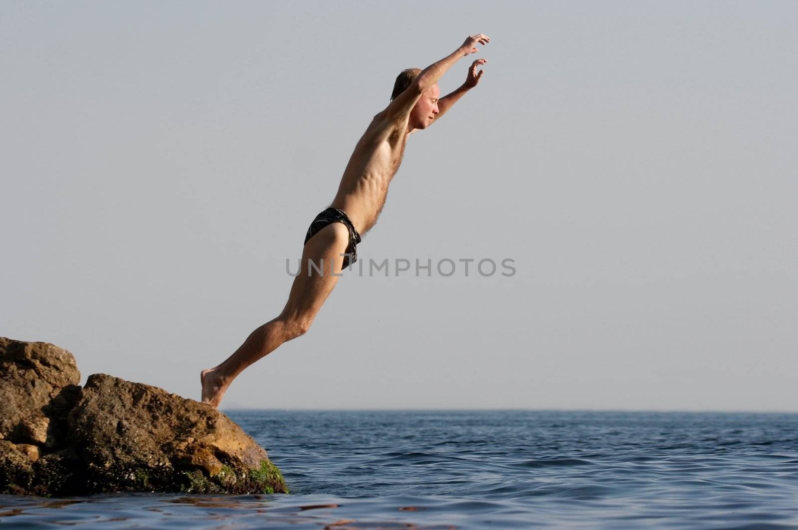 Man jumping in the water of the sea