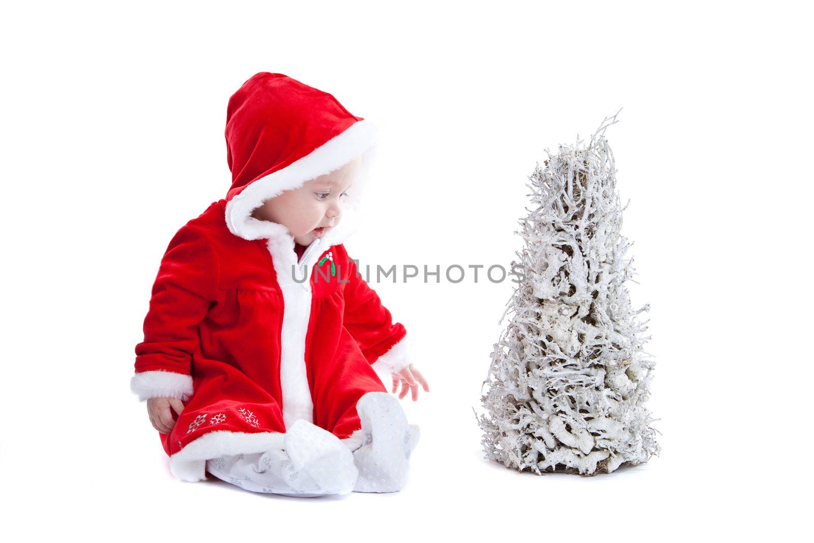 Cute little baby girl with santa suit and christmas tree on white background