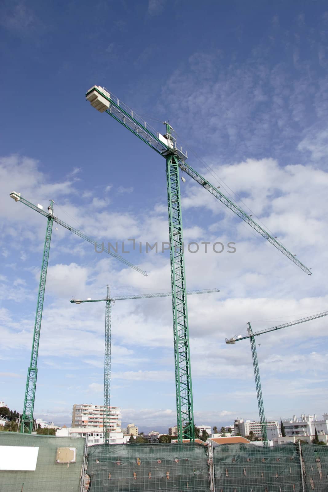four large cranes on a construction site