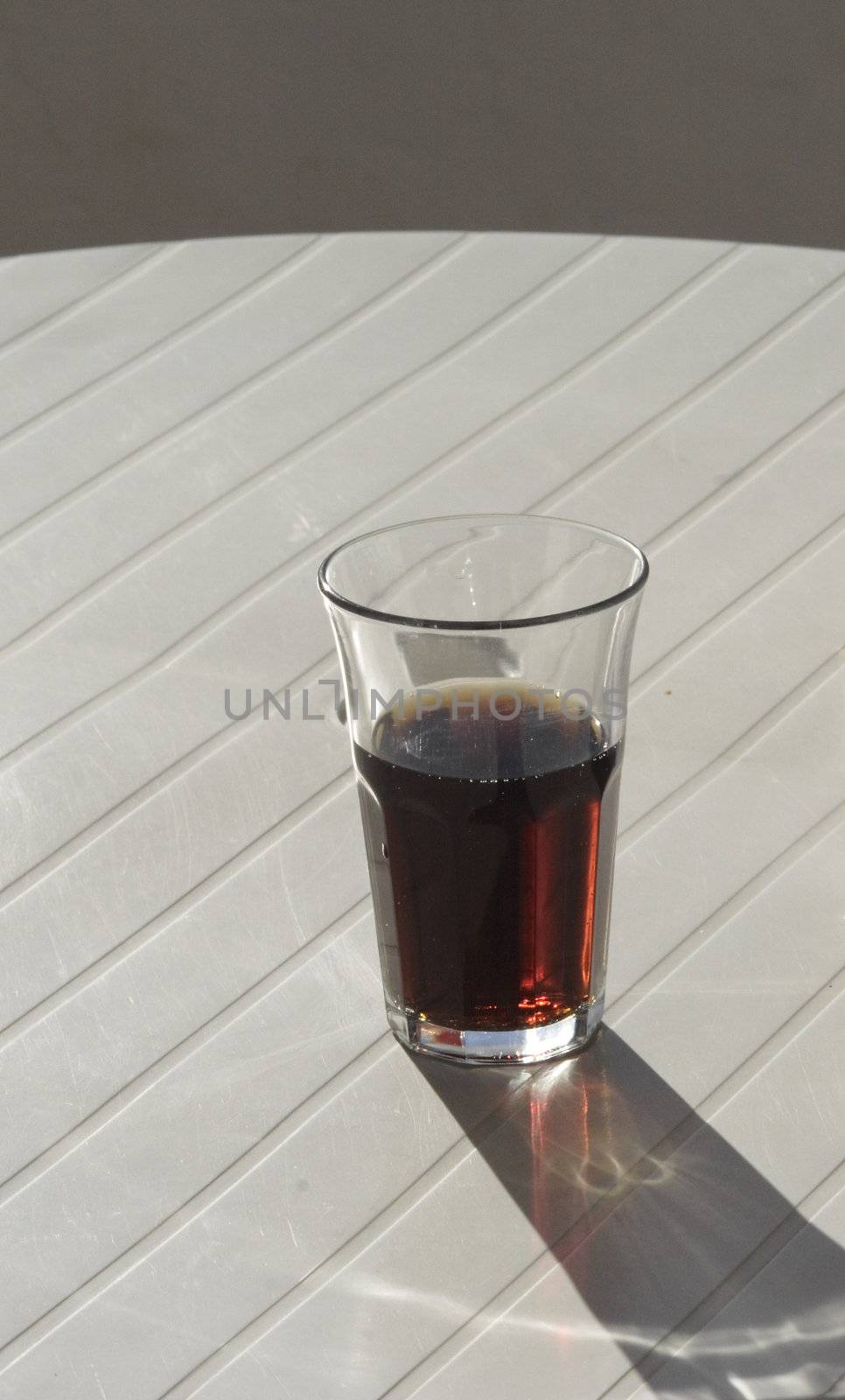 a half glass of coke drink on a white table
