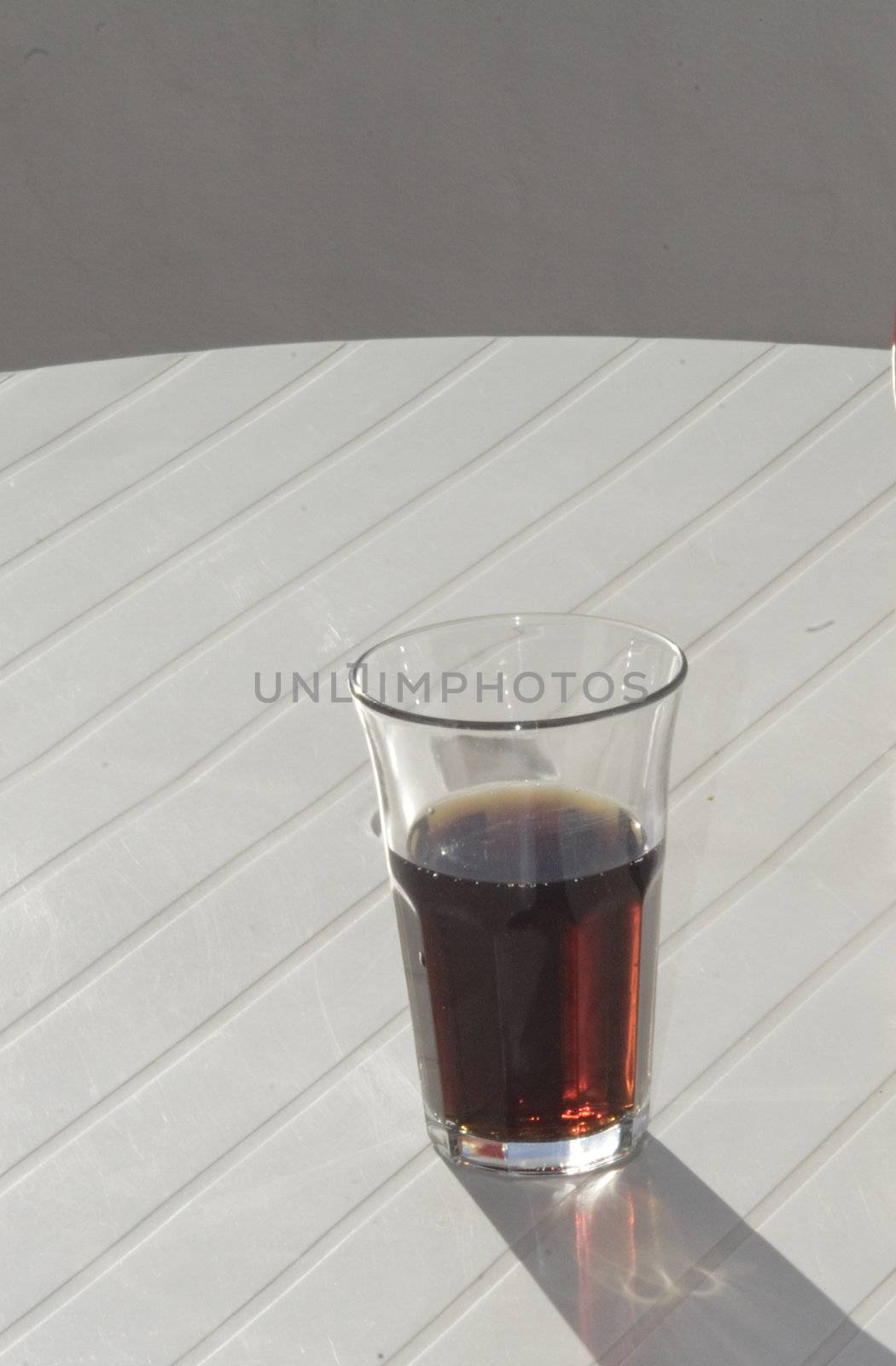 a half glass of coke drink on a white table