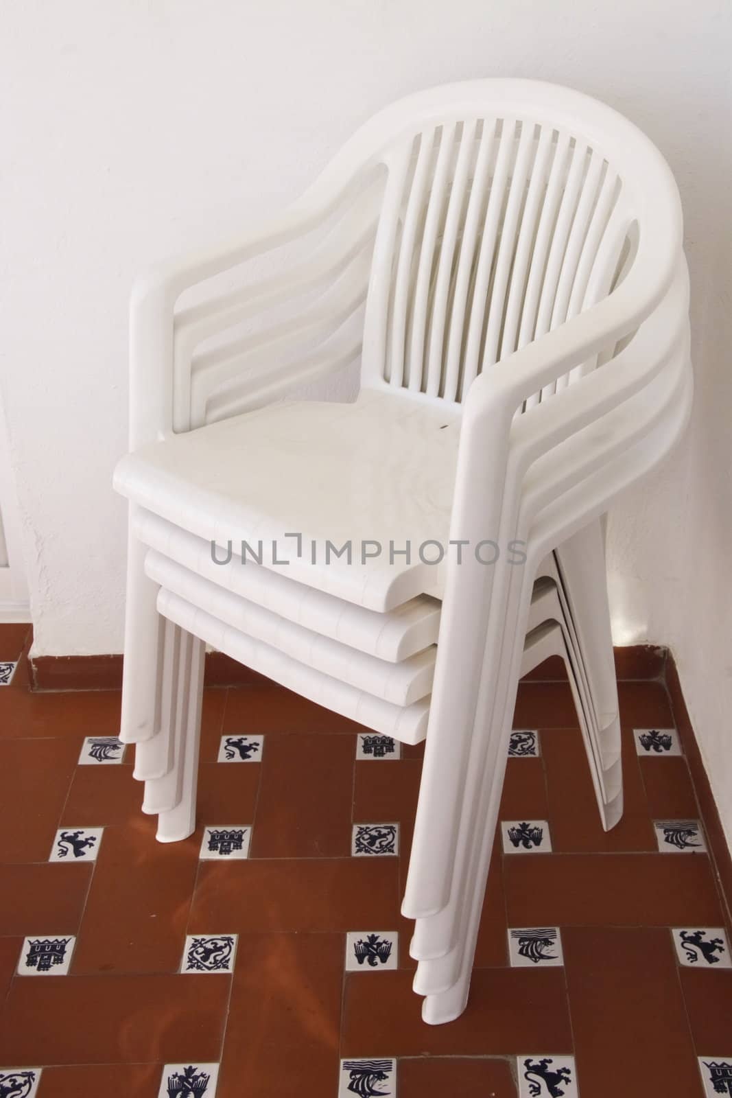 a stack of white plastic chairs on a patiio