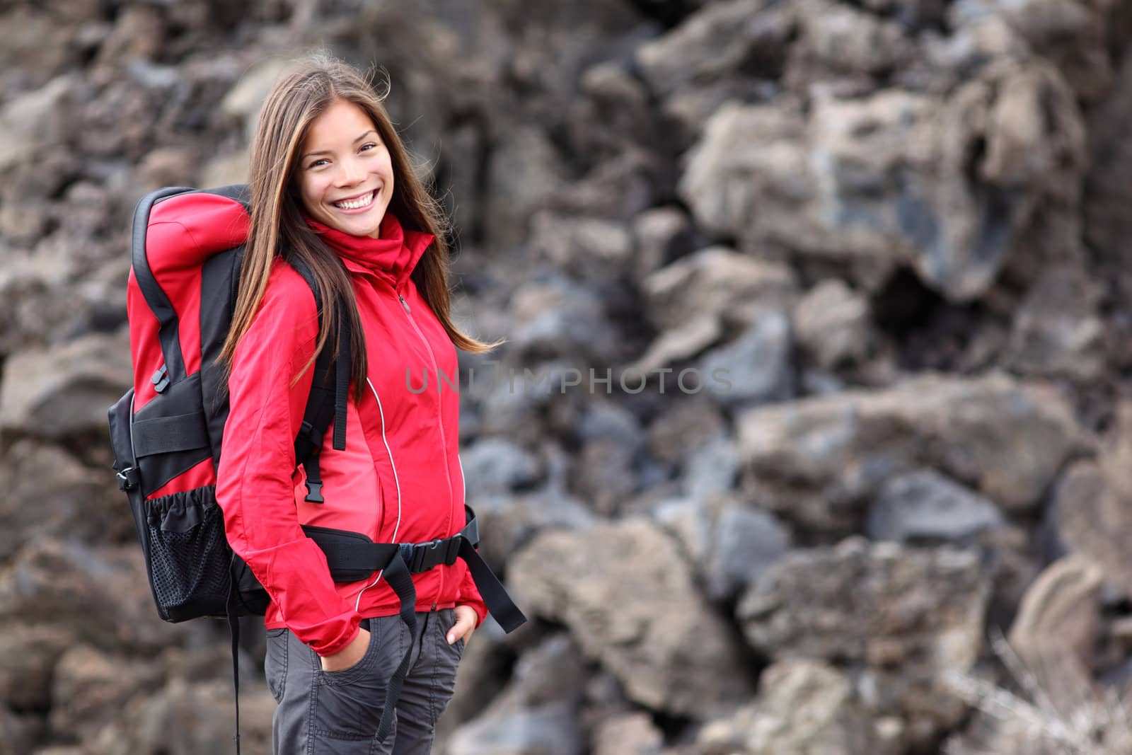 Smiling young woman hiker hiking outdoors. Portrait of mixed race Asian / Caucasian model. Photo from Teide, tenerife.