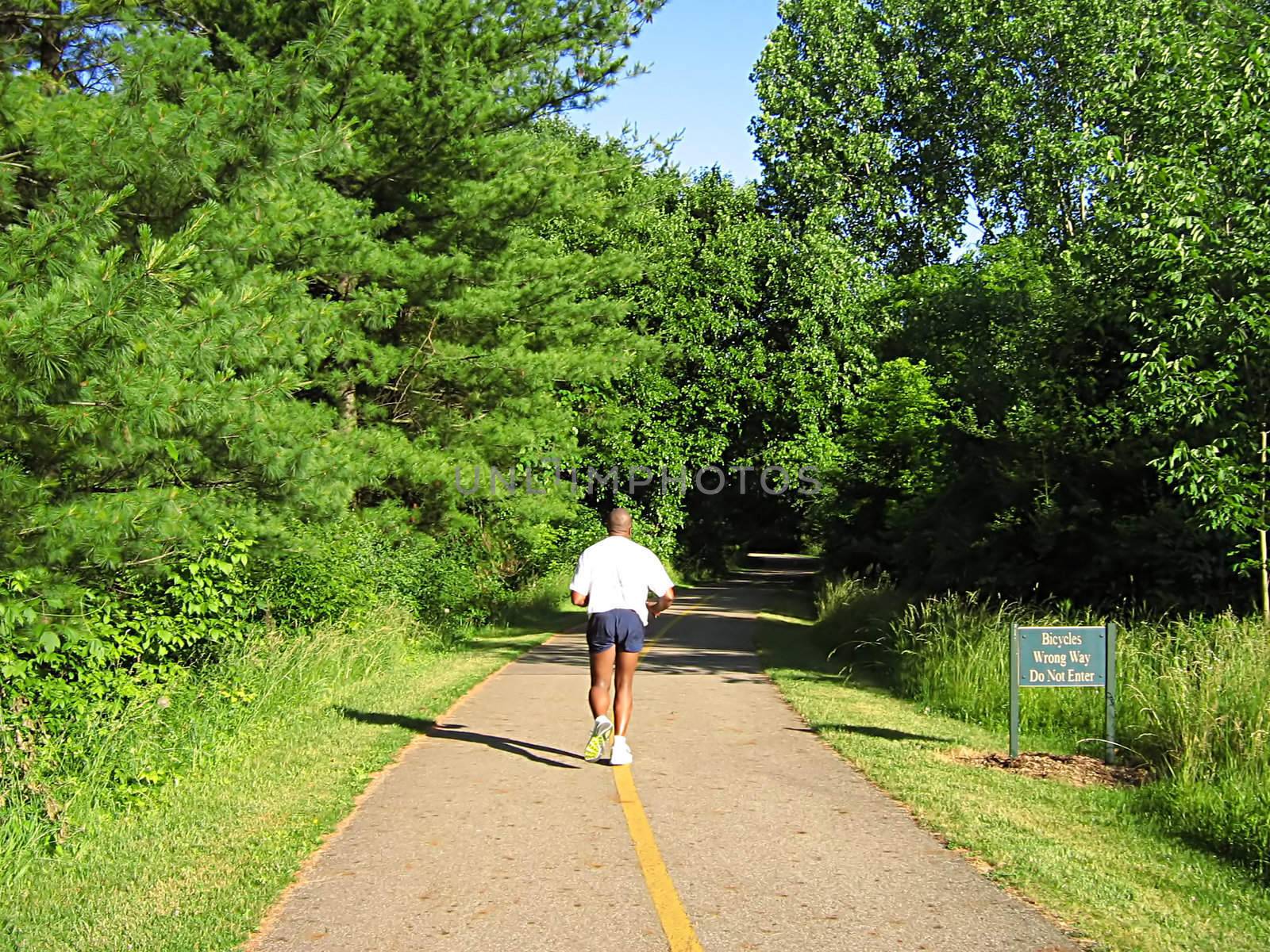 A photograph of a person running along a trail.