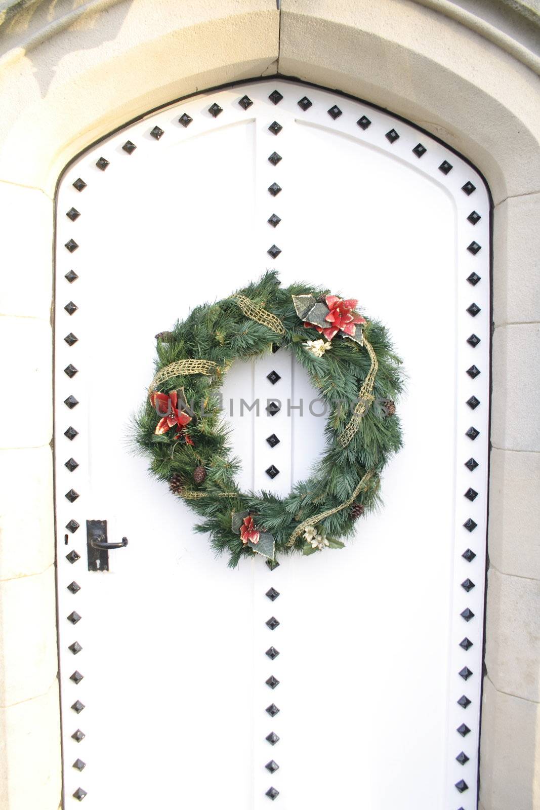 a wreath on a white door to welcome visitors as they approach the door