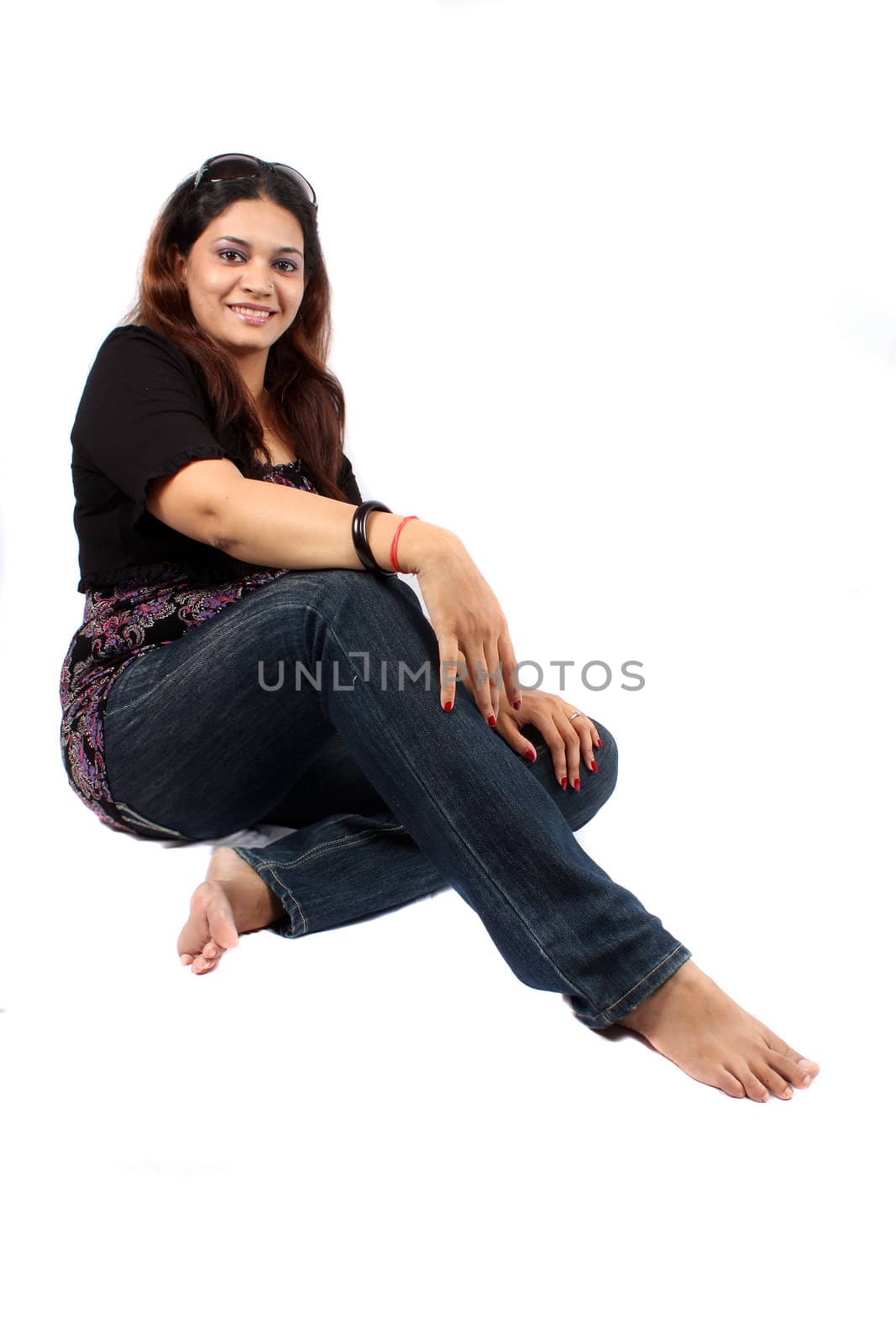 A smart Indian lady sitting on the floor.