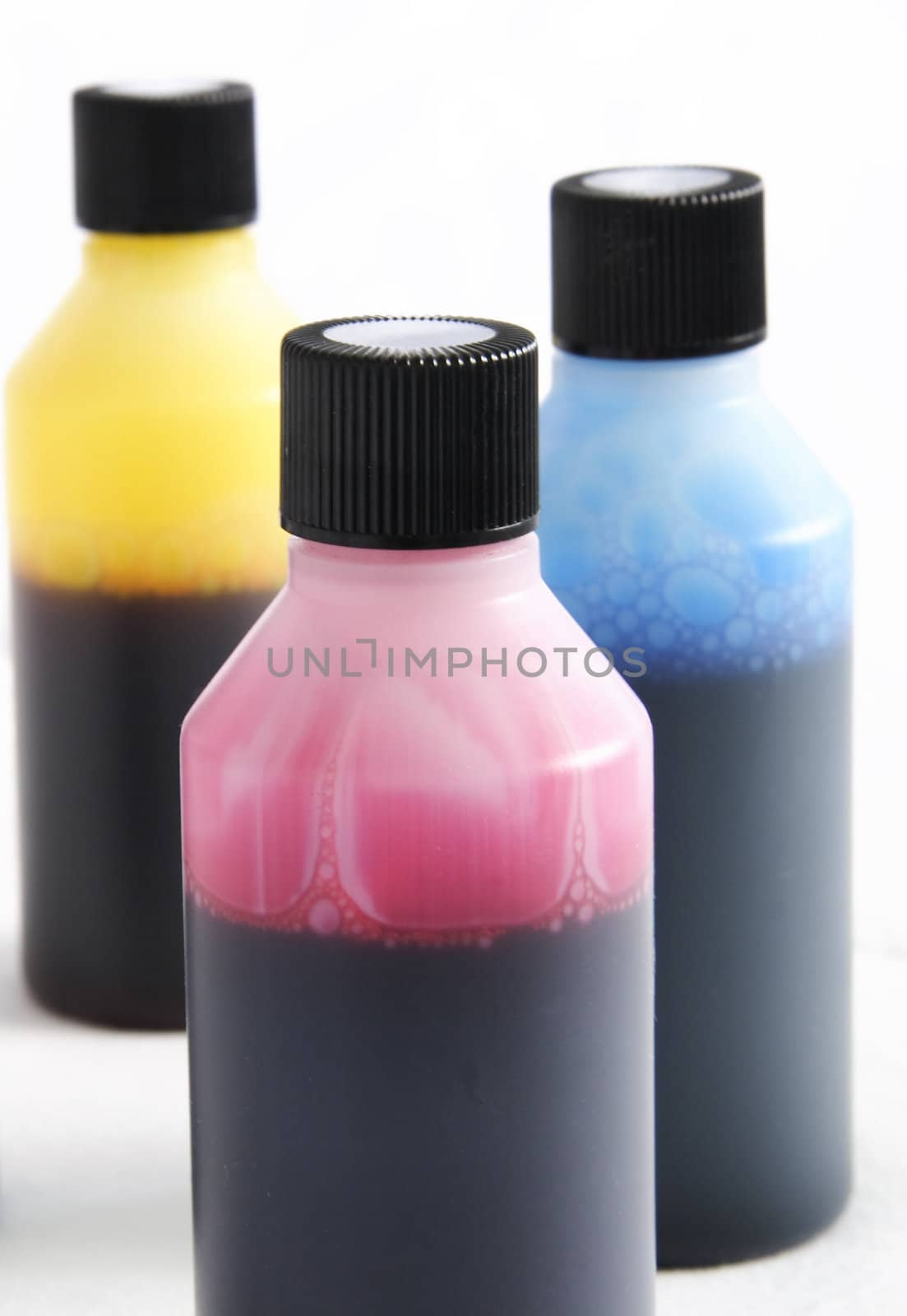 three plastic bottles with different coloured ink in each