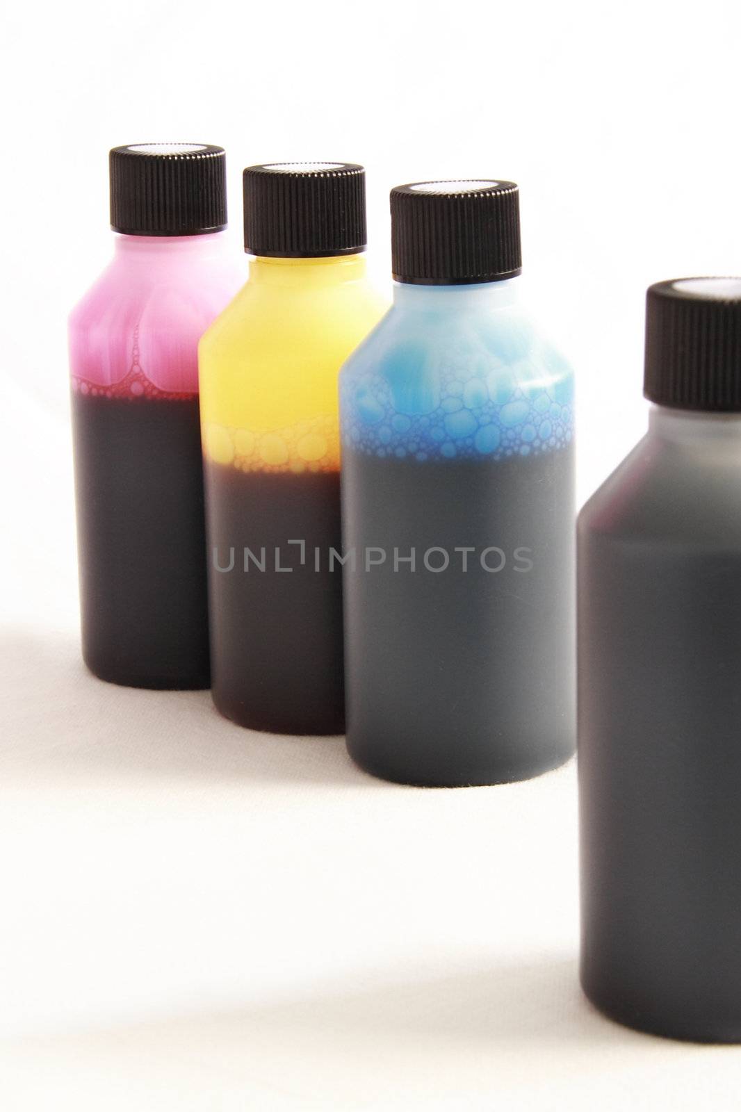 four plastic bottles with different coloured ink in each