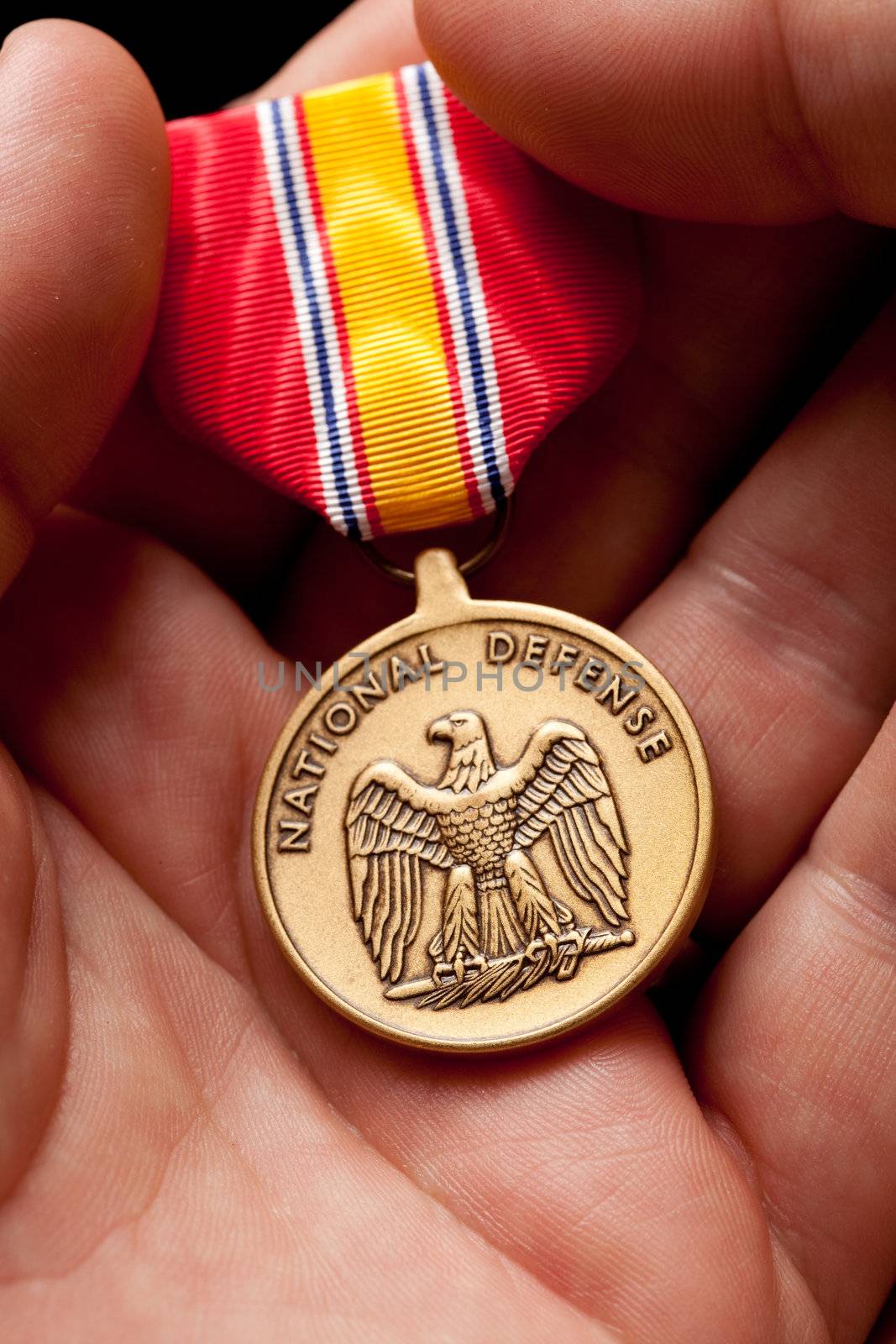 Man Holding National Defense War Medal by Feverpitched