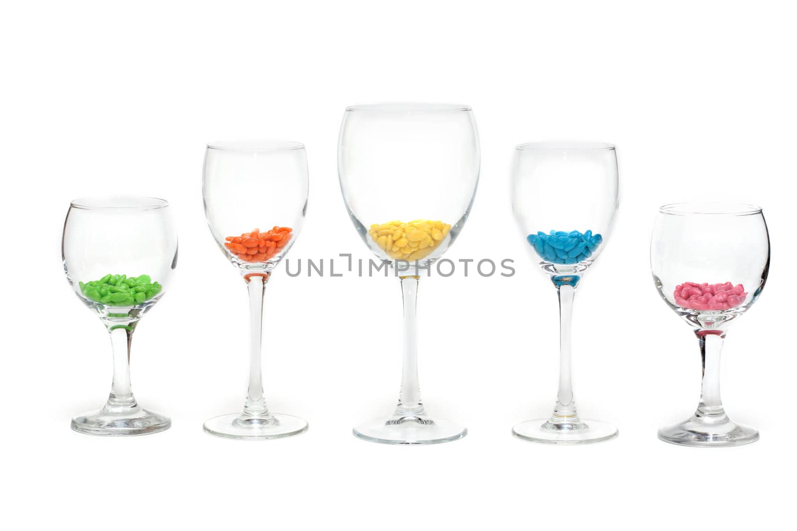 Tall wine glasses exposed in row on white background with colour sweetmeat