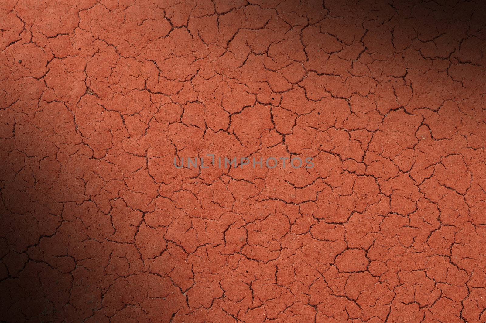 Cracked red textured surface background, dramatically lit diagonally