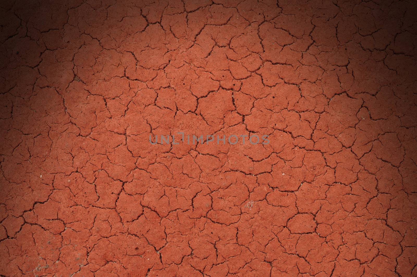 Cracked red textured surface background, dramatically lit from above