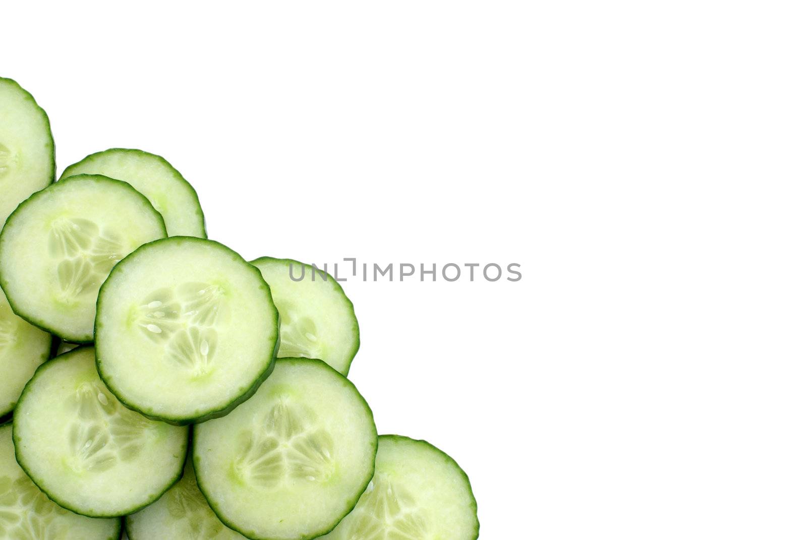 Many cucumber slices at the bottom left of the frame, leaving room for copy-space.
