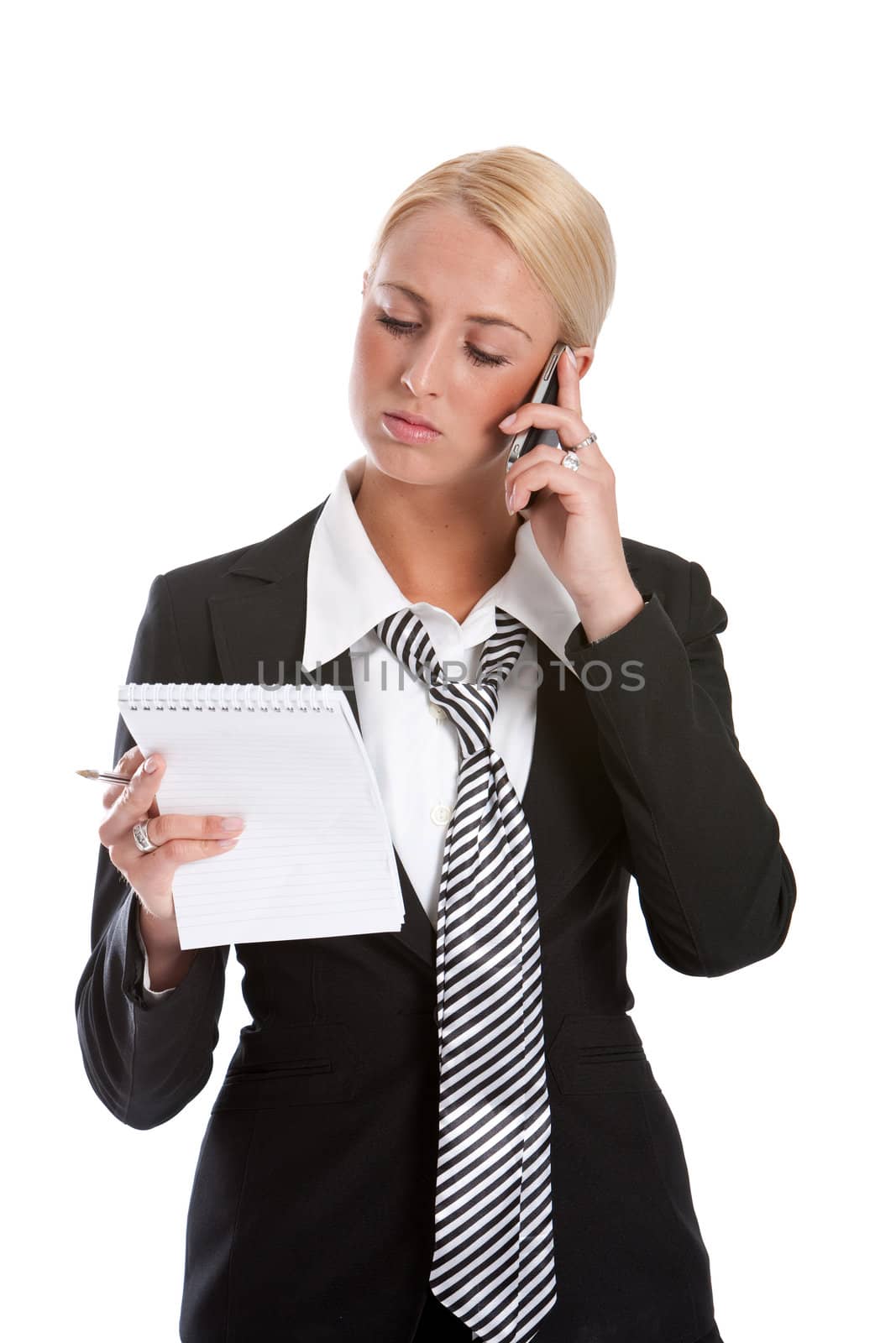 Beautiful young businesswoman checking her notes while on the phone