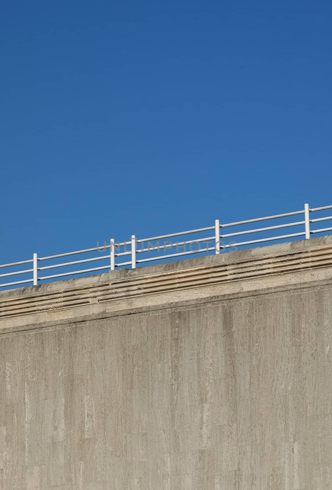 concrete wall and railings against a blue sky